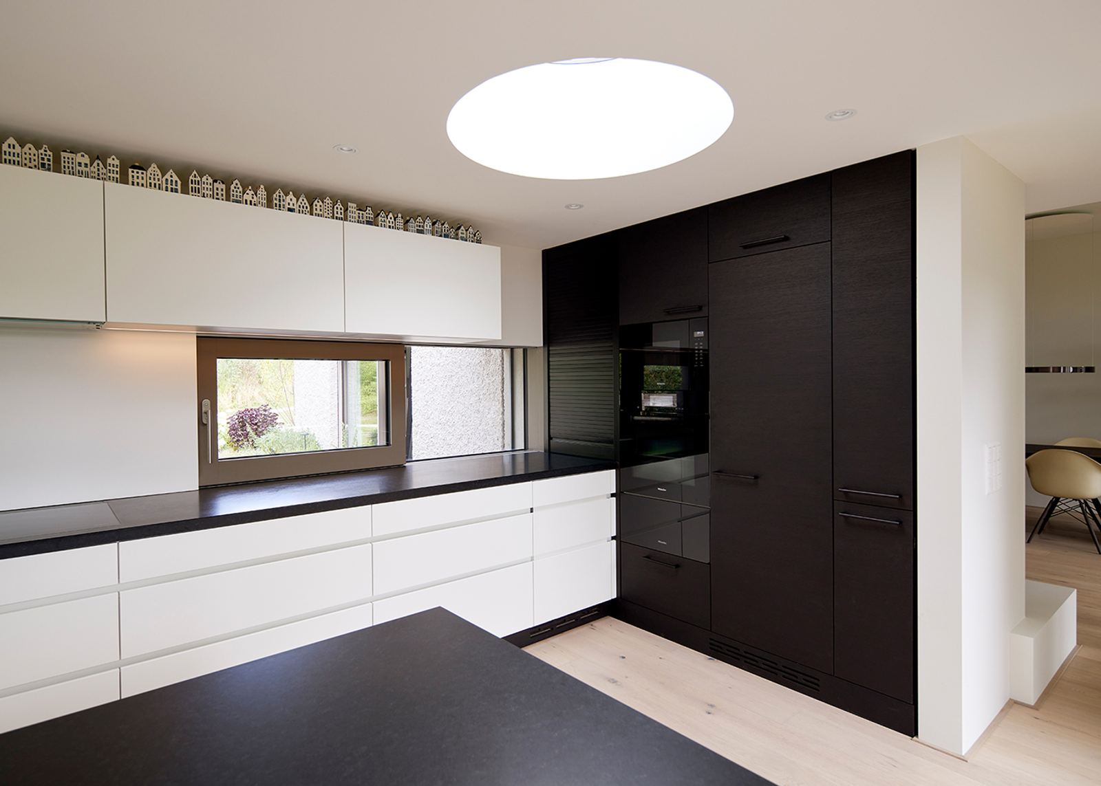 Kitchen with white fronts and circular skylight