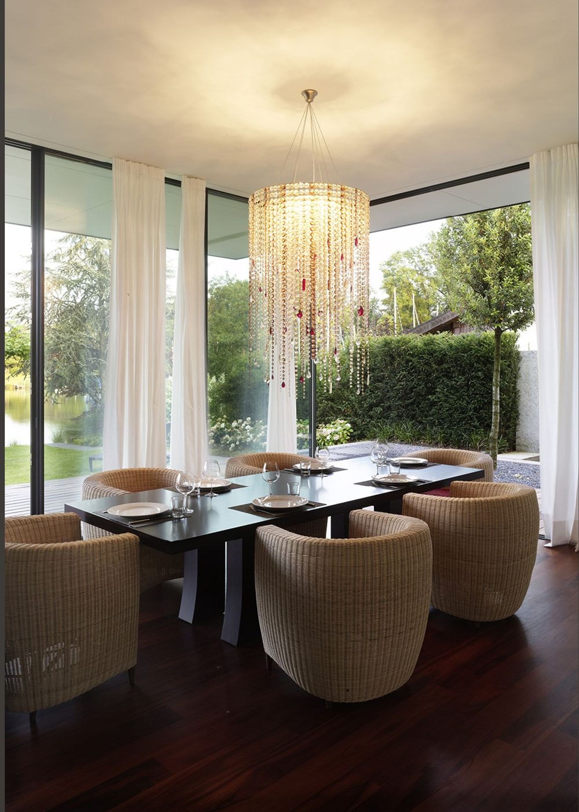 Dining table with armchairs beneath the crystal chandelier – Single-family house in Lachen