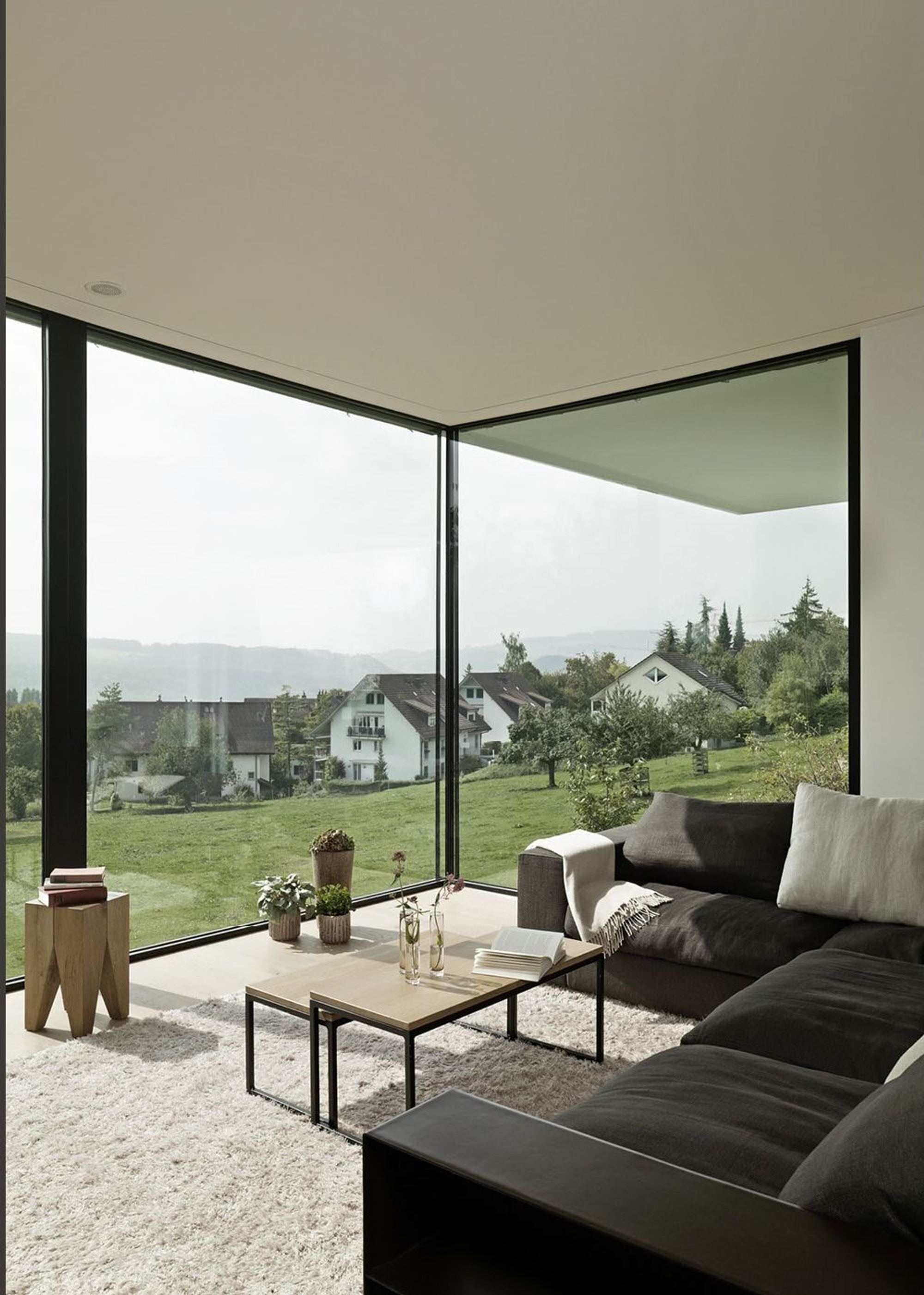 Corner window with sofa and green view – Single-family house in Uitikon