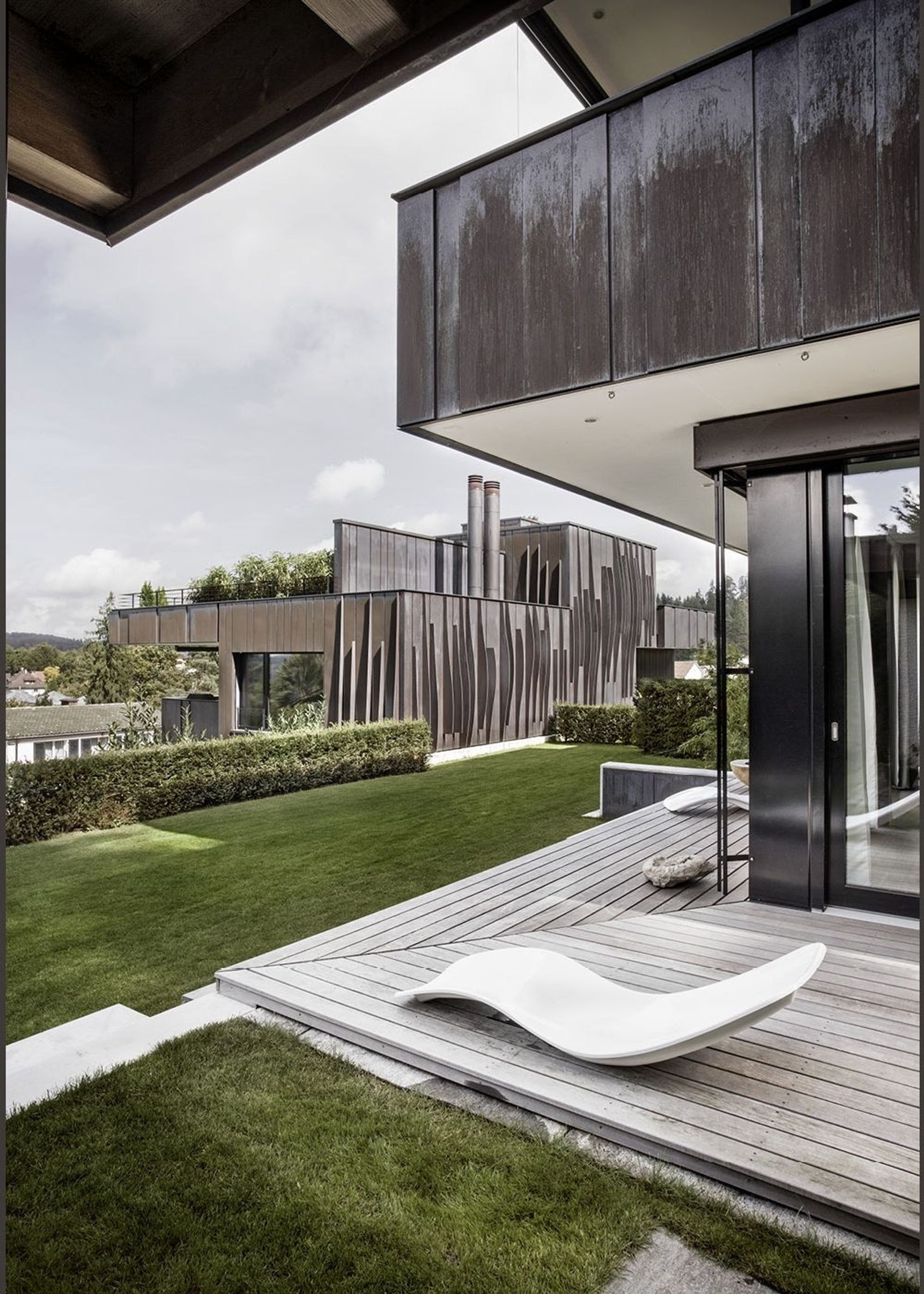 Timber deck with lounger under the canopy – Apartment building in Uitikon