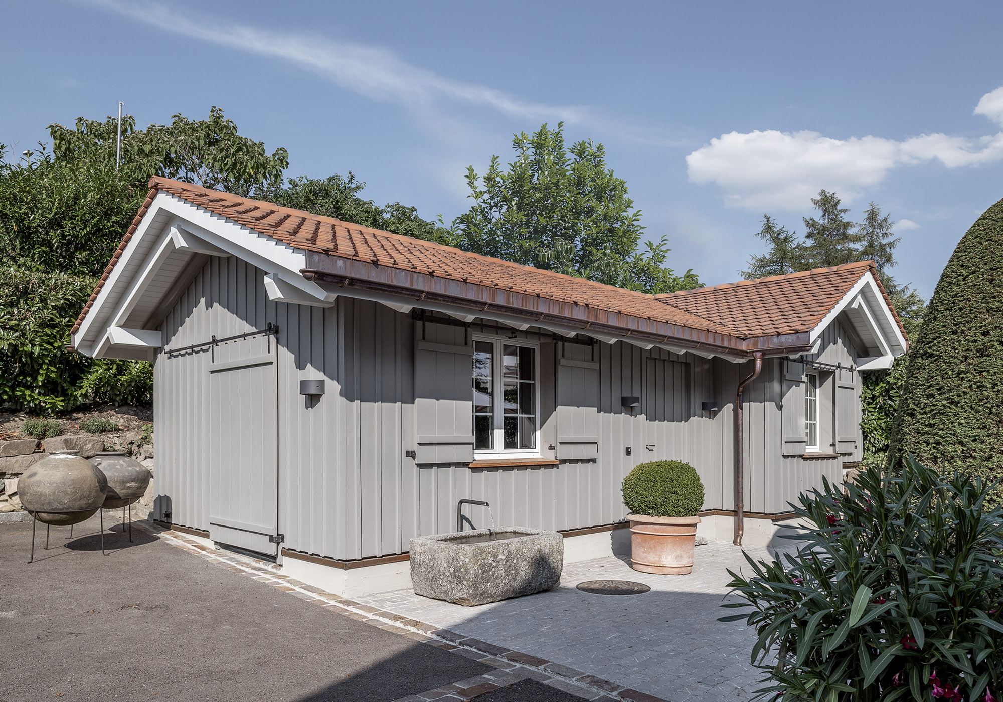 Garden house with grey timber cladding and tiled roof – Single-family house in Uitikon