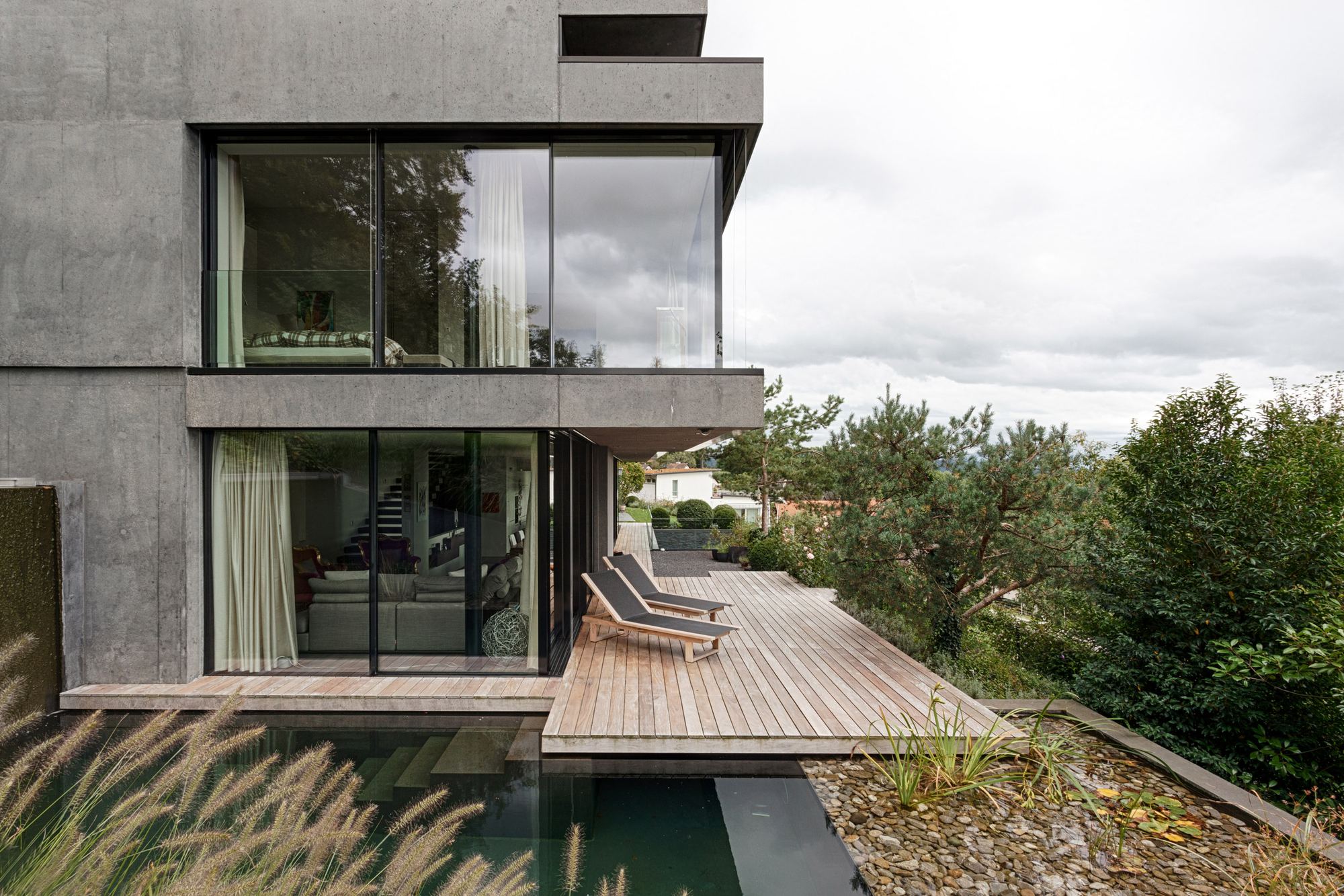 Timber deck by the water basin with grasses – Single-family house in Uitikon