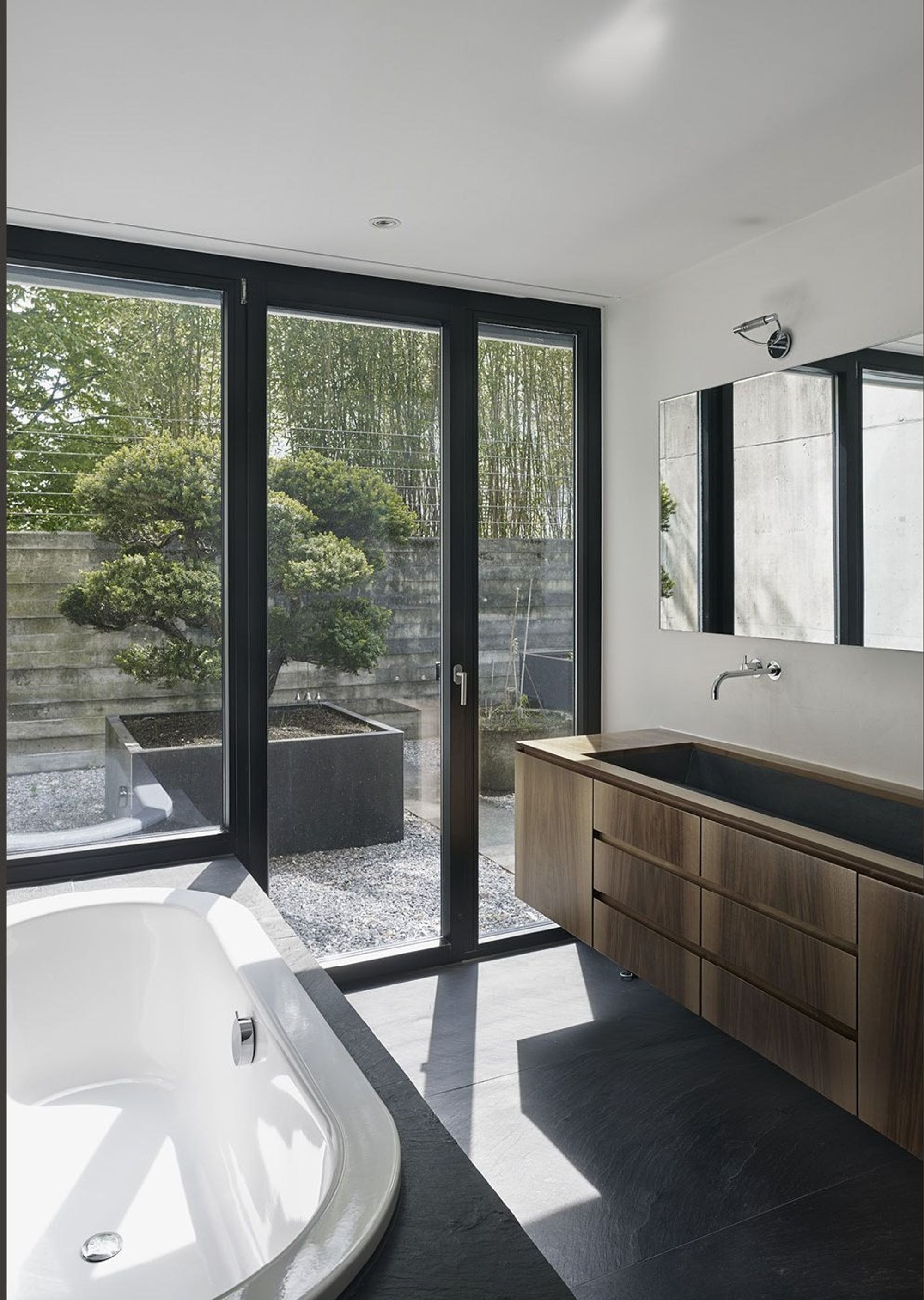 Bathroom with bathtub and green view – Apartment building in Uitikon