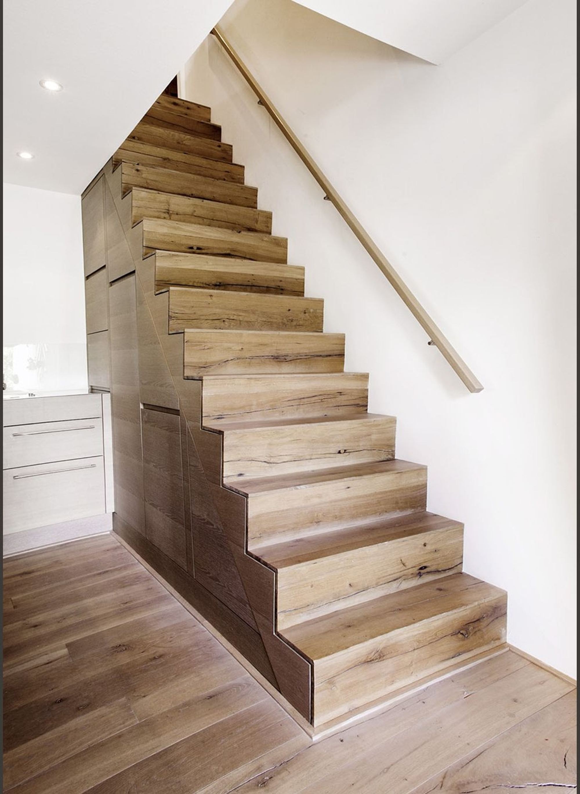 Timber staircase with handrail on a white wall – Historic conversion in Uerikon