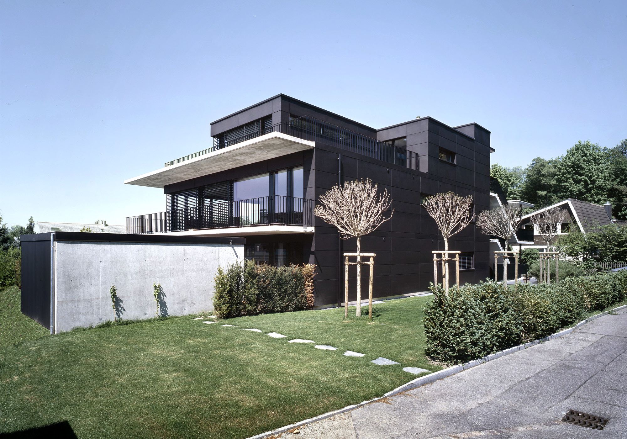 Dark facade with terraces and lawn – Apartment building in Uitikon