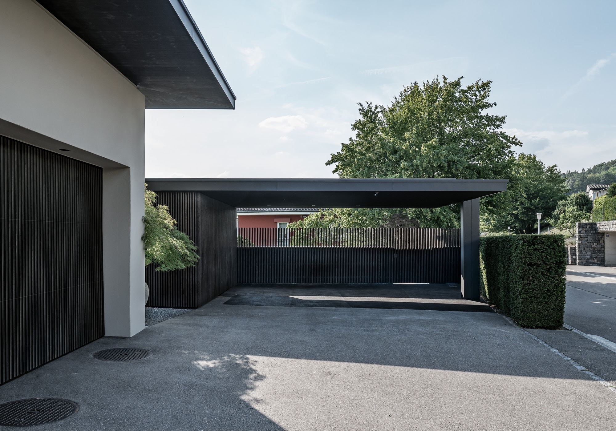 Carport with dark roof and forecourt – Single-family house in Uitikon