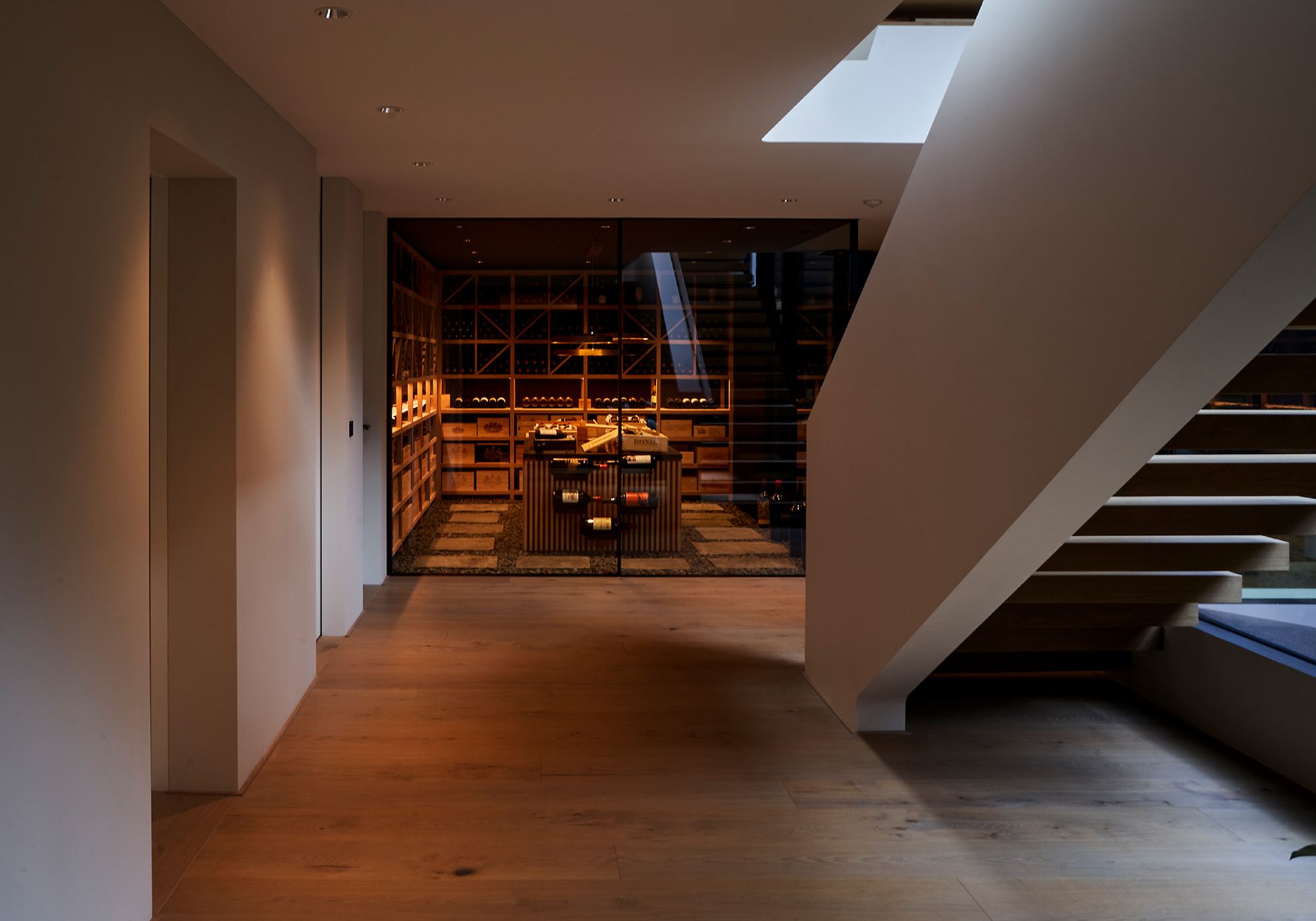 Hallway with view into the lit wine cellar – Single-family house in Schindellegi