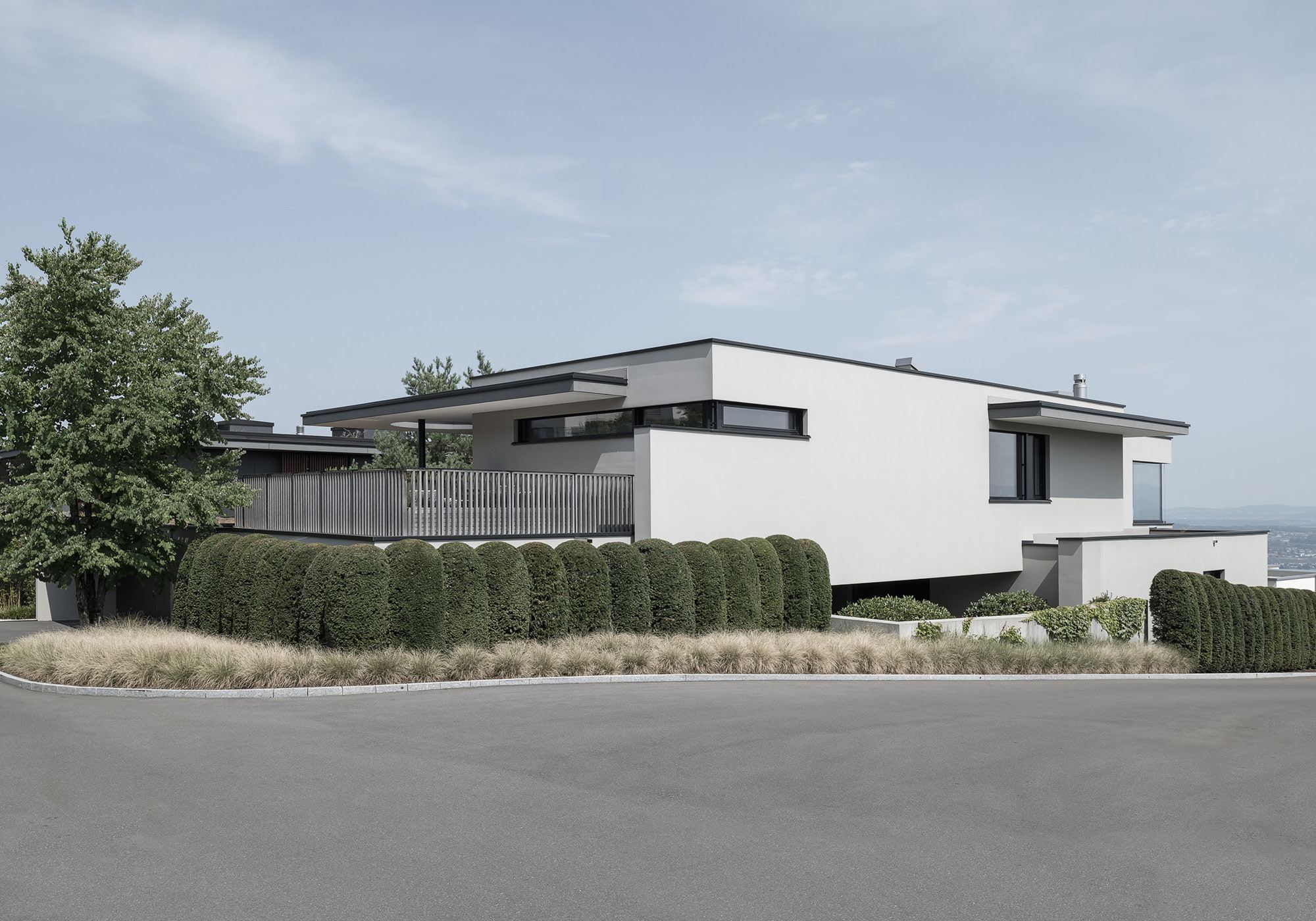 Street view with hedge and white building – Single-family house in Schindellegi