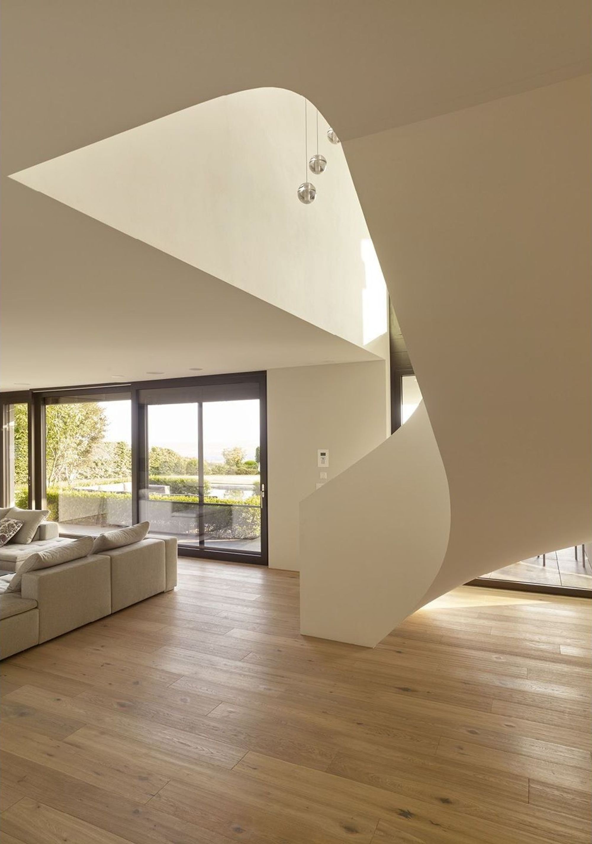 Curved white staircase in the living space – Single-family house in Oberwil-Lieli