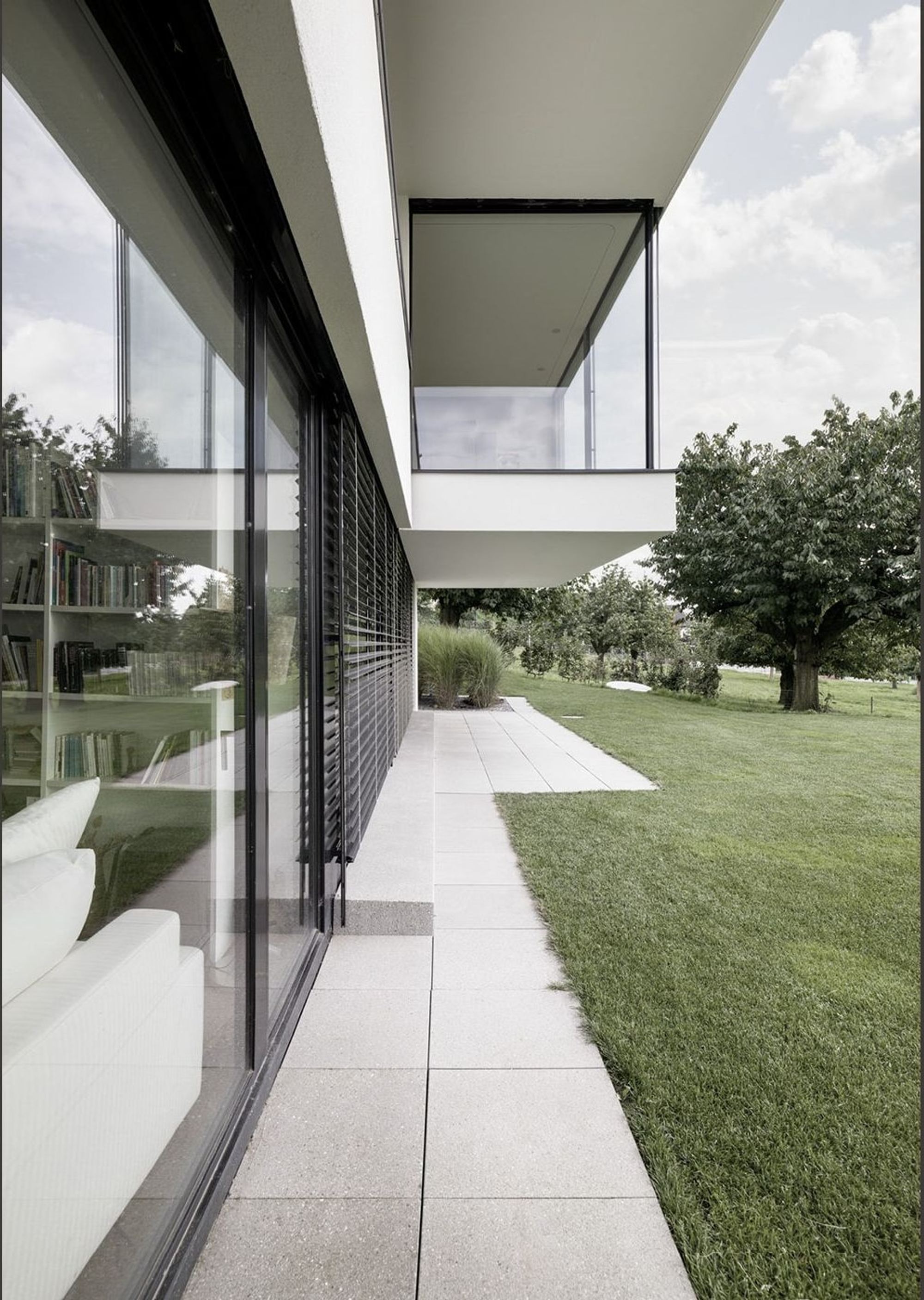 Paved path under the canopy along the glass front – Single-family house in Uitikon