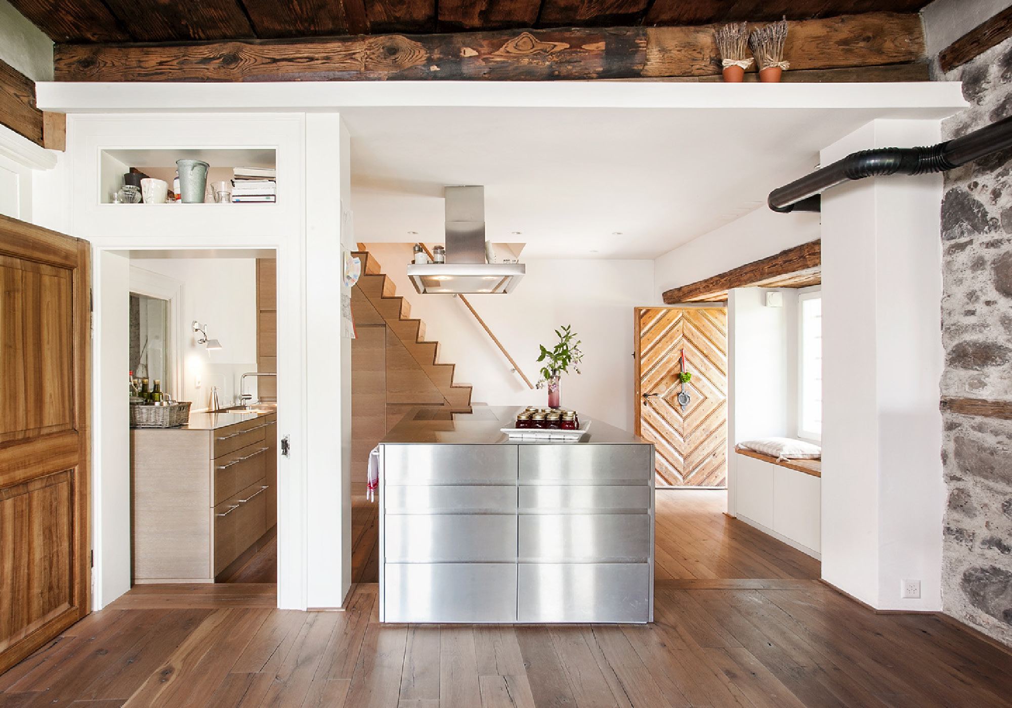 Stainless steel kitchen beneath old ceiling beams – Historic conversion in Uerikon