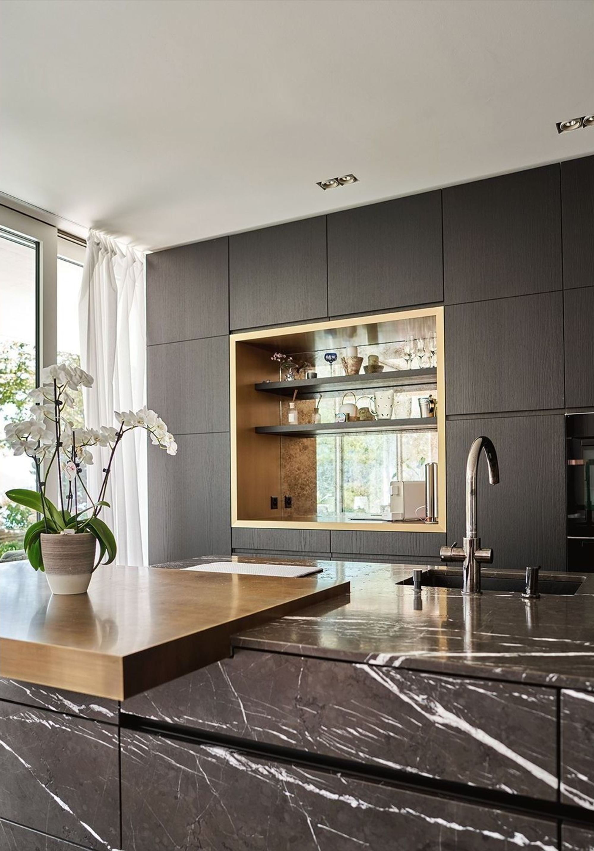 Marble kitchen island in front of dark cabinetry – Interiors and landscape, Luzern