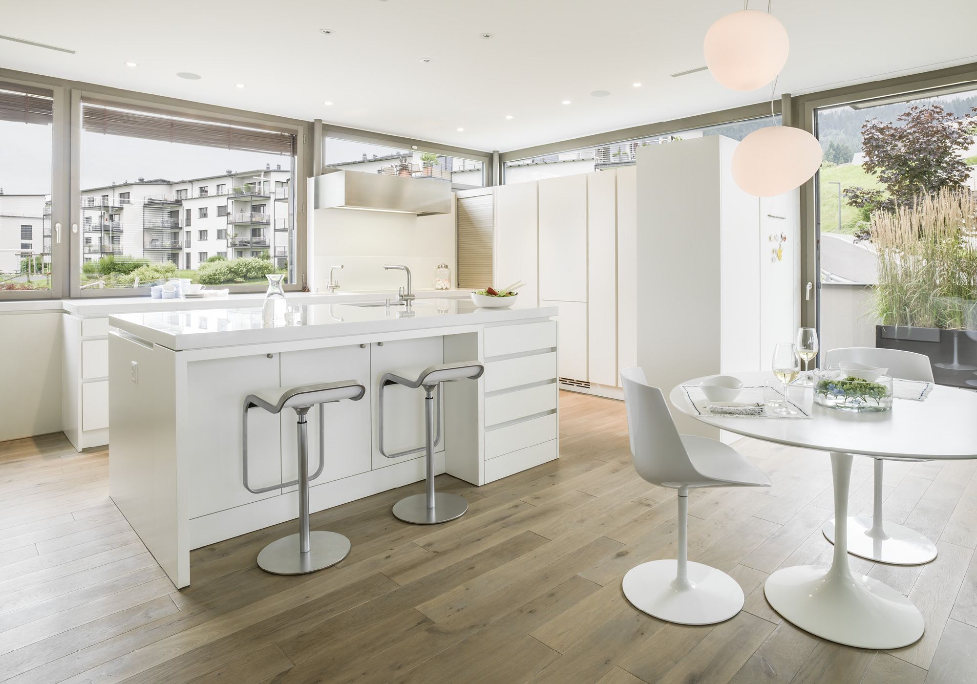 White kitchen with bar stools and round table – Single-family house in Schindellegi
