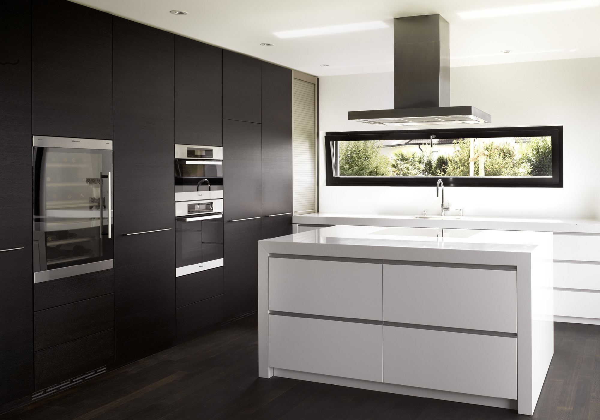 White island in front of dark tall cabinets – Single-family house in Möriken
