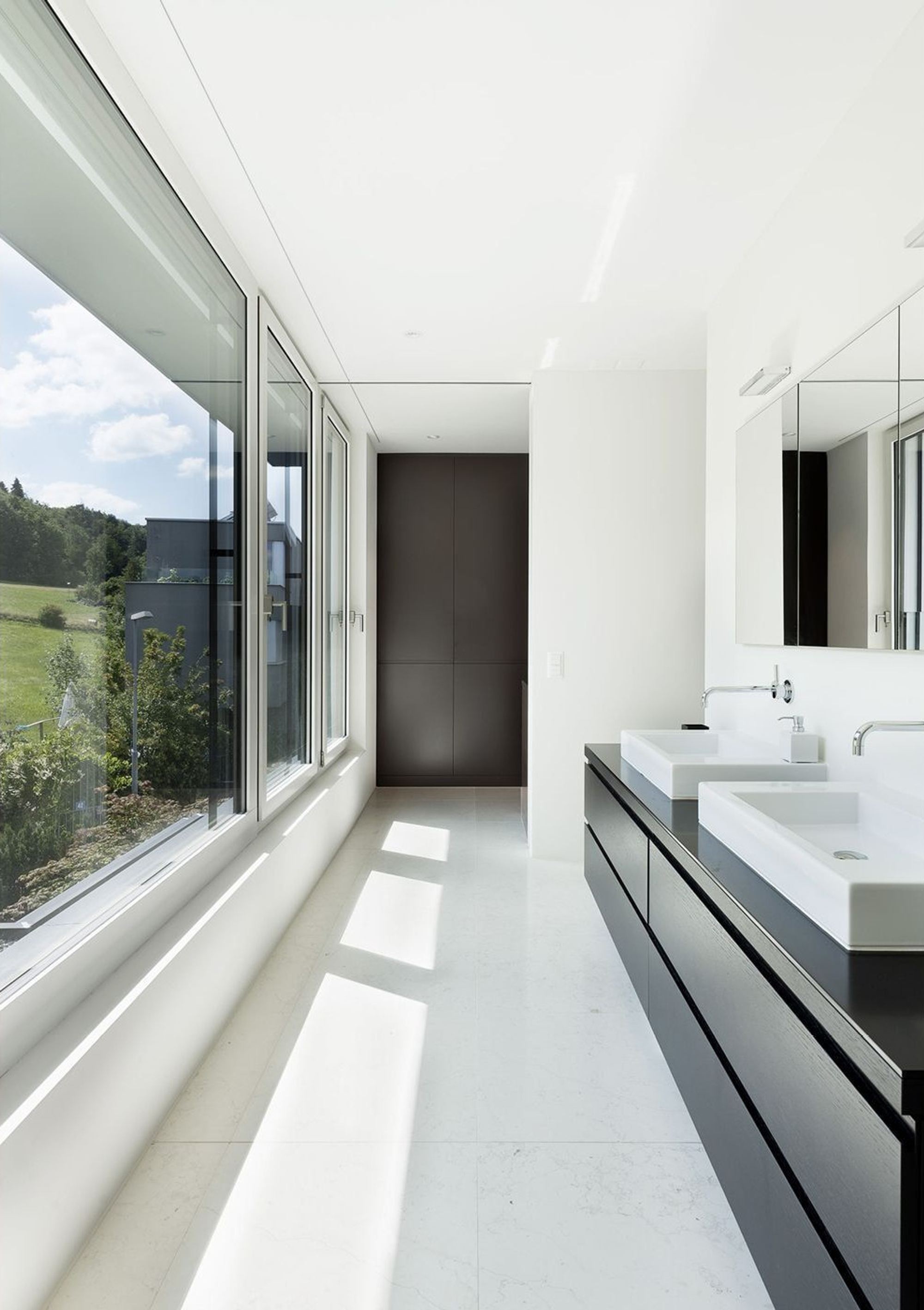 Bathroom with double vanity and long window – Single-family house in Zürich