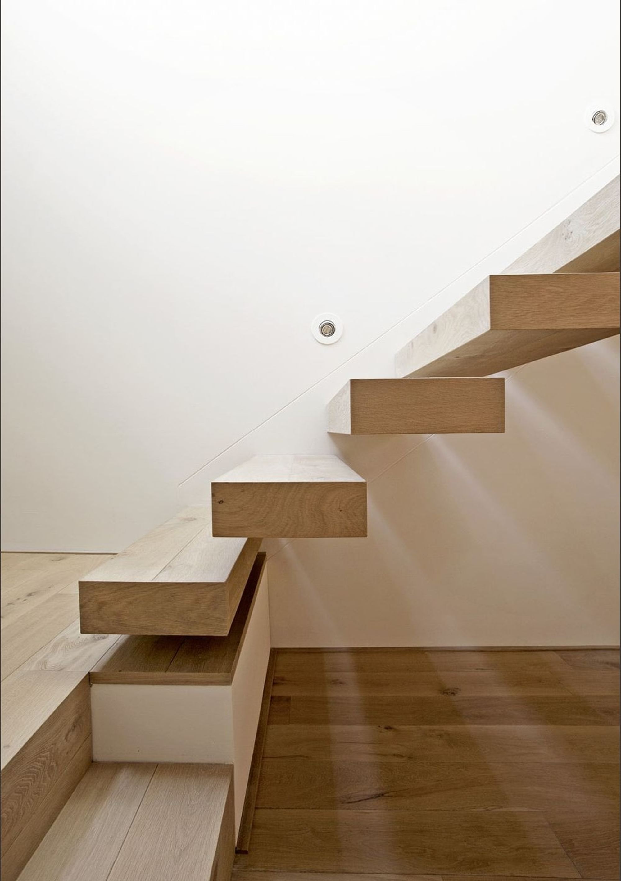 Timber staircase against a white wall – Apartment building in Uitikon