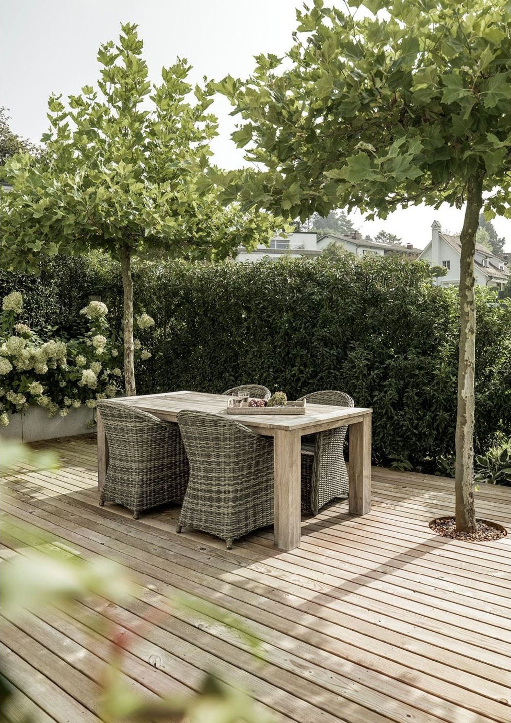 Timber deck with dining table under trees – Single-family house in Uitikon