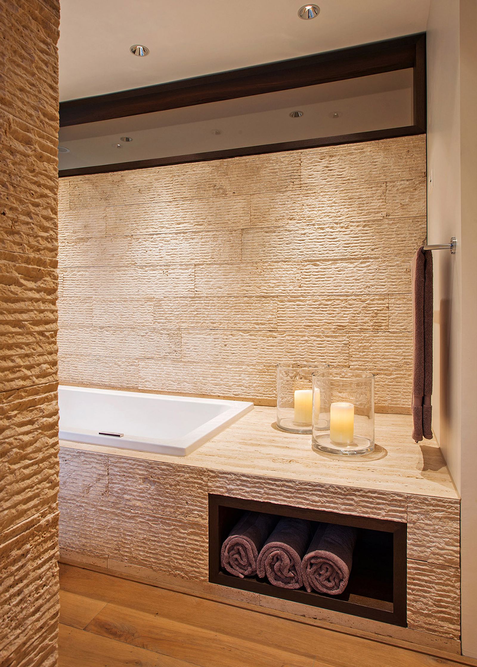 Bathtub with natural stone wall and candles