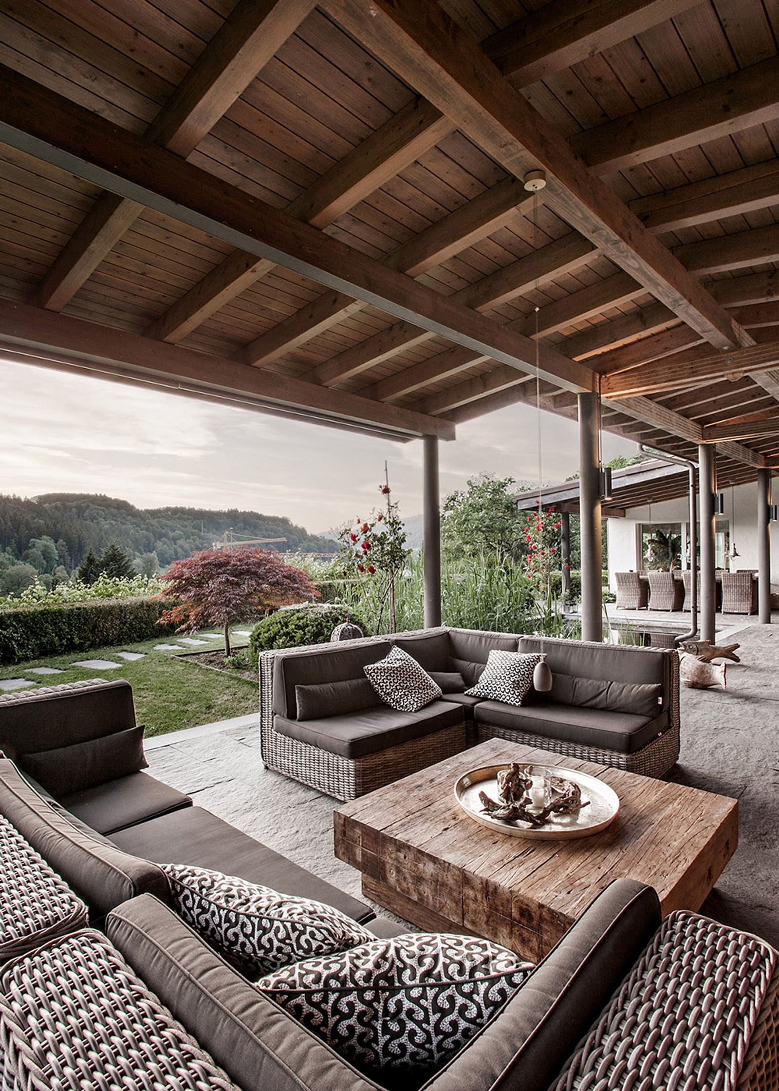 Lounge furniture under the timber roof with view into the valley