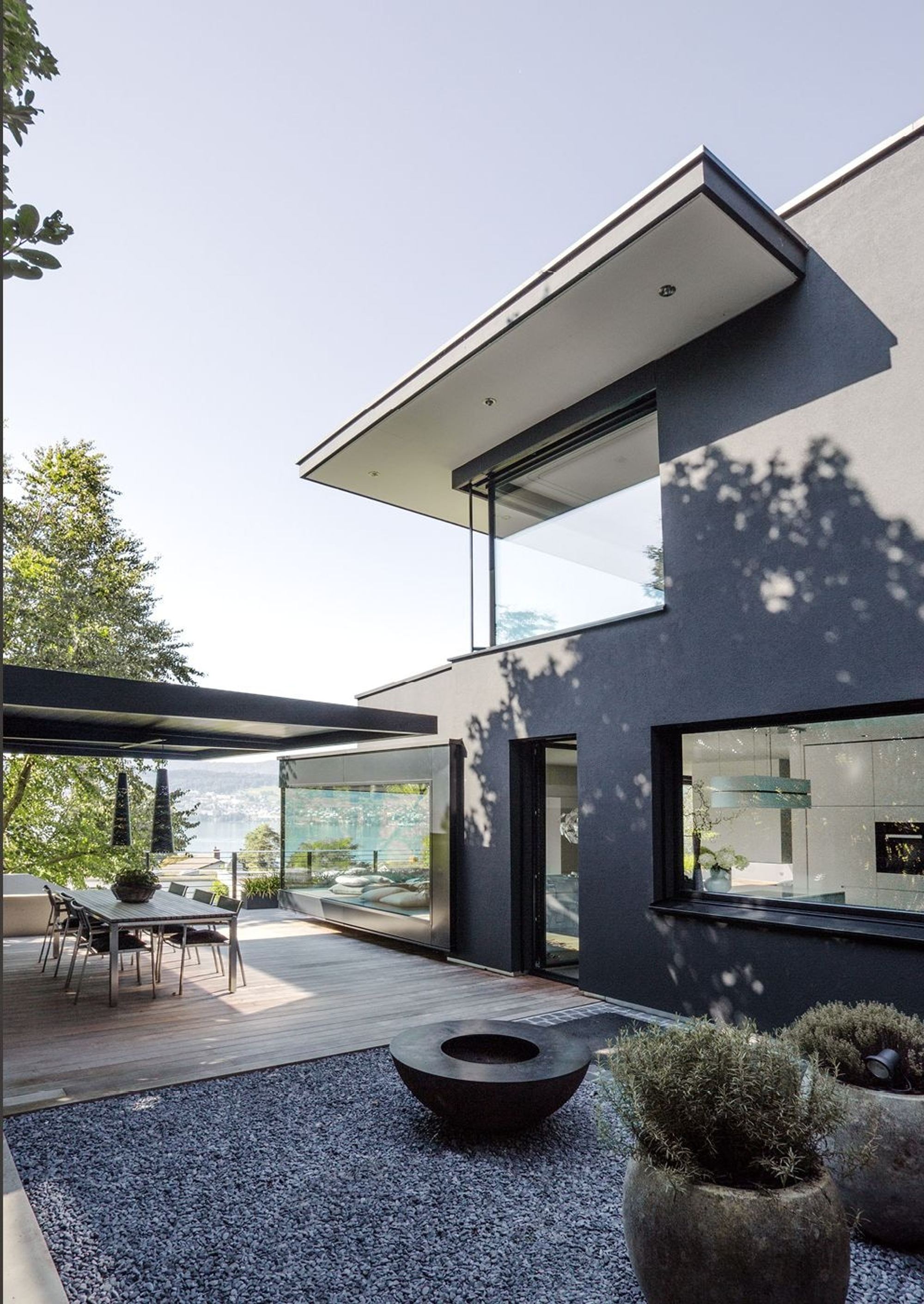 Courtyard with seating area and cantilevered roof – Single-family house in Meilen