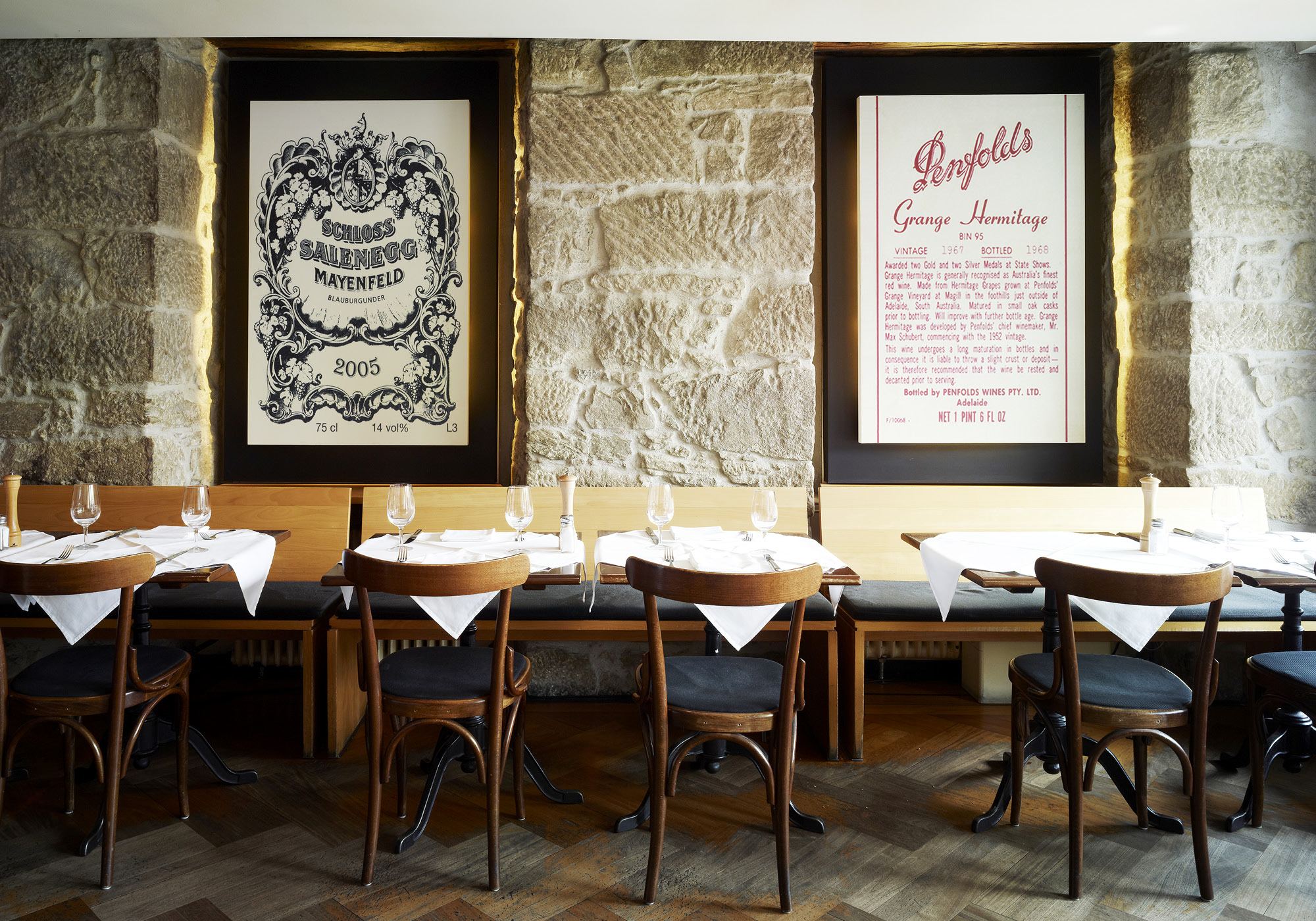 Restaurant with natural stone wall and wine posters – Interiors and landscape, Zürich