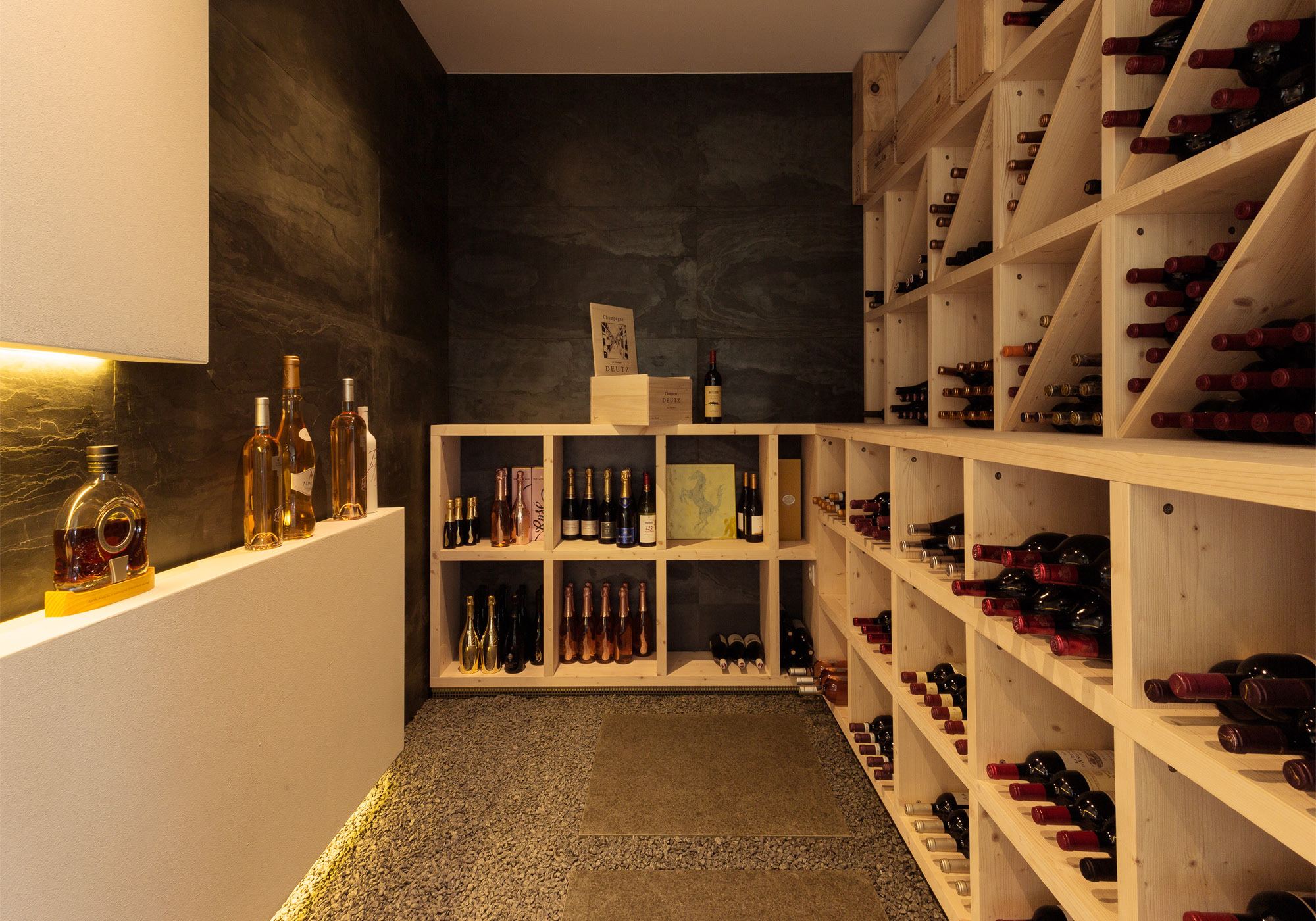 Wine cellar with timber racks and lit counter – Single-family house in Oberwil-Lieli