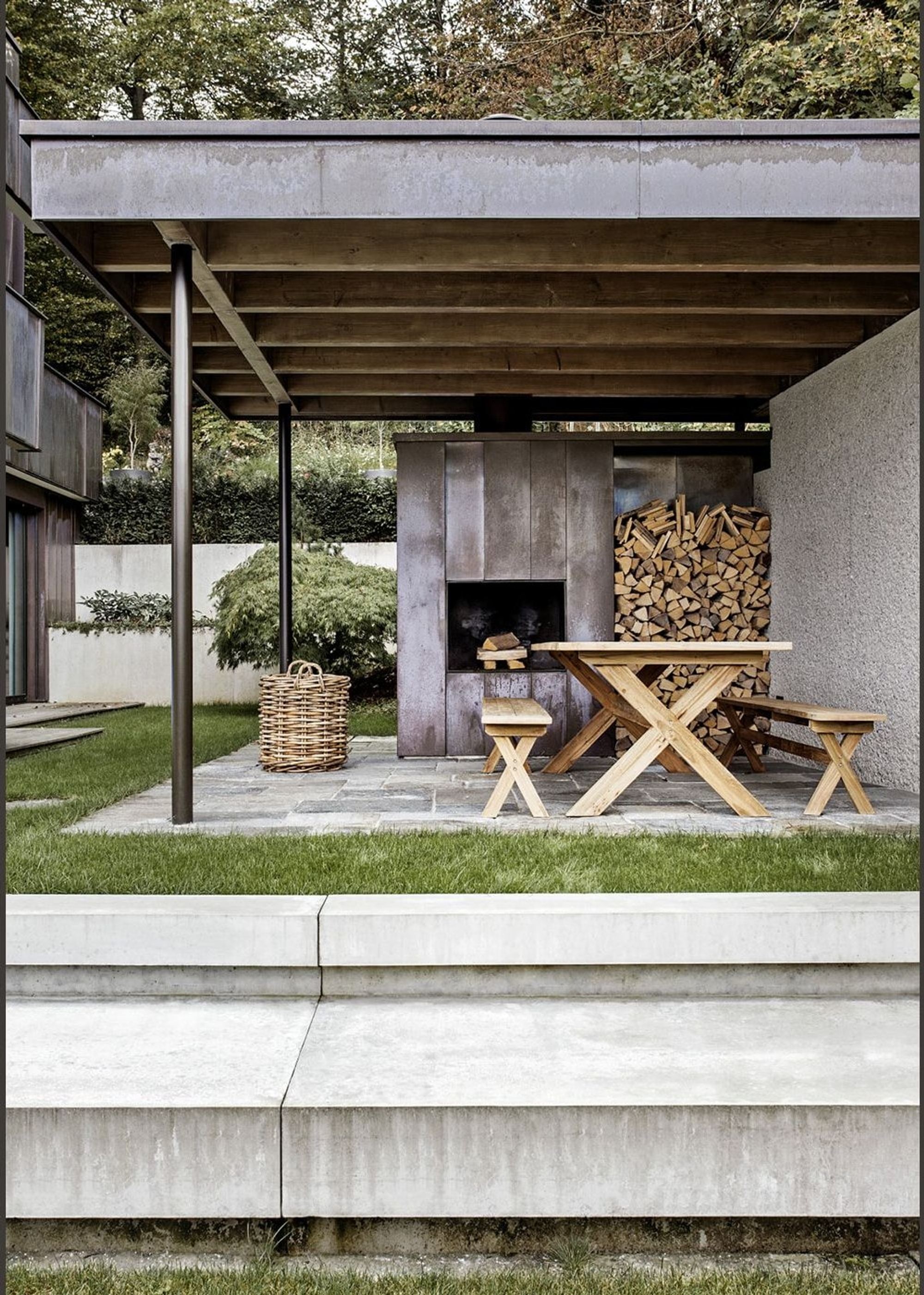 Covered seating area with timber table and firewood – Apartment building in Uitikon