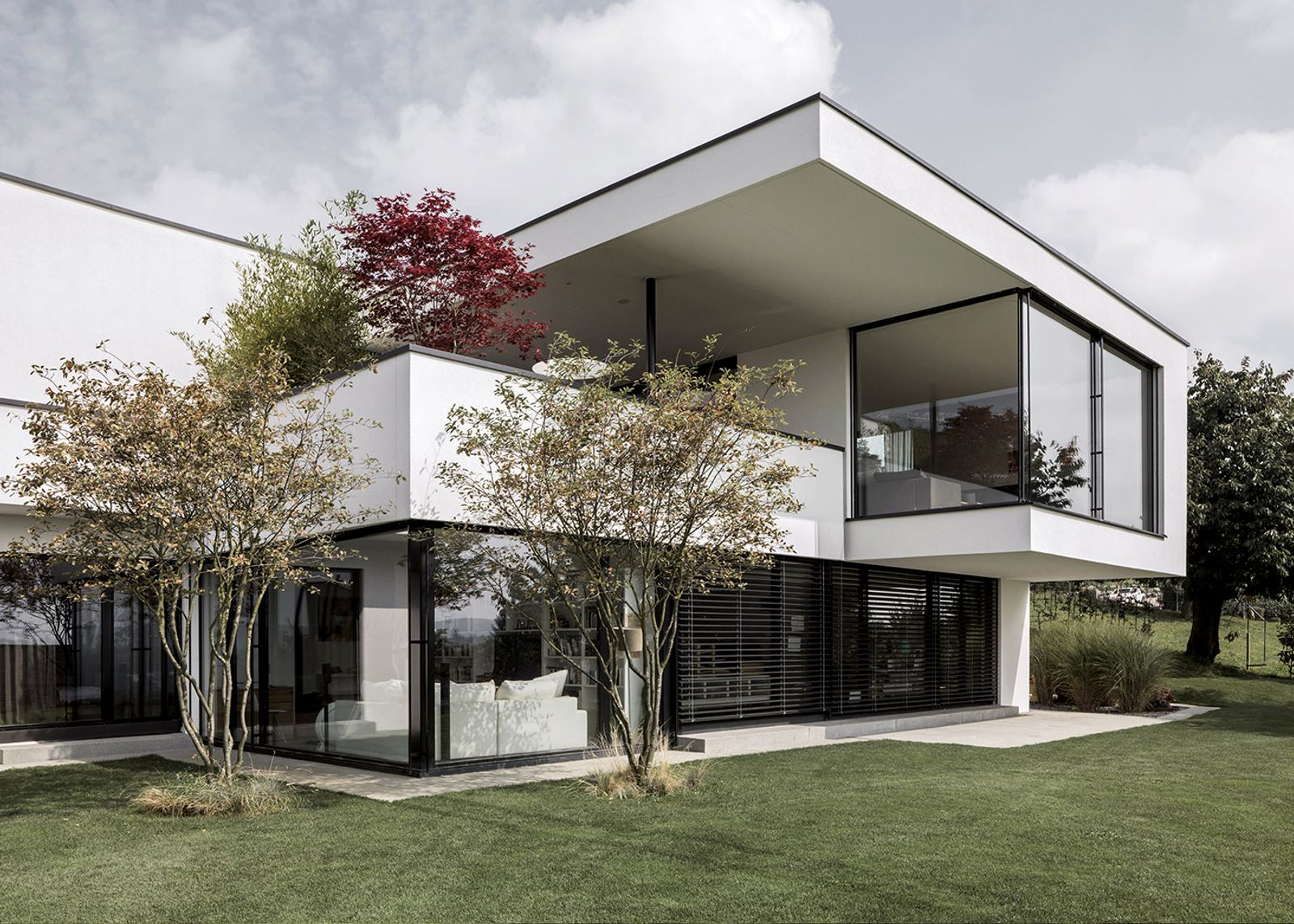 White facade with trees and lawn