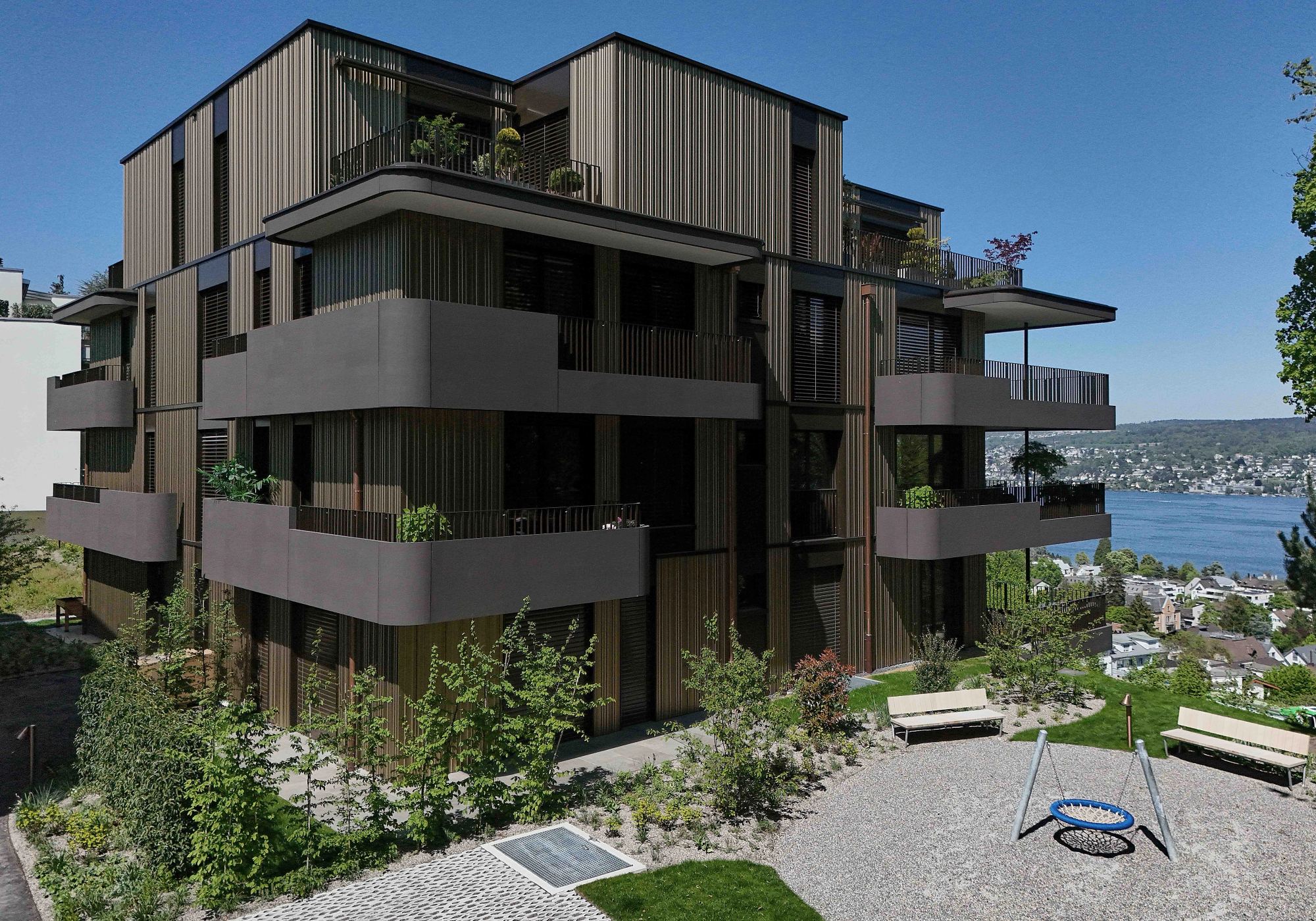 Courtyard side with playground and lake view – Apartment building