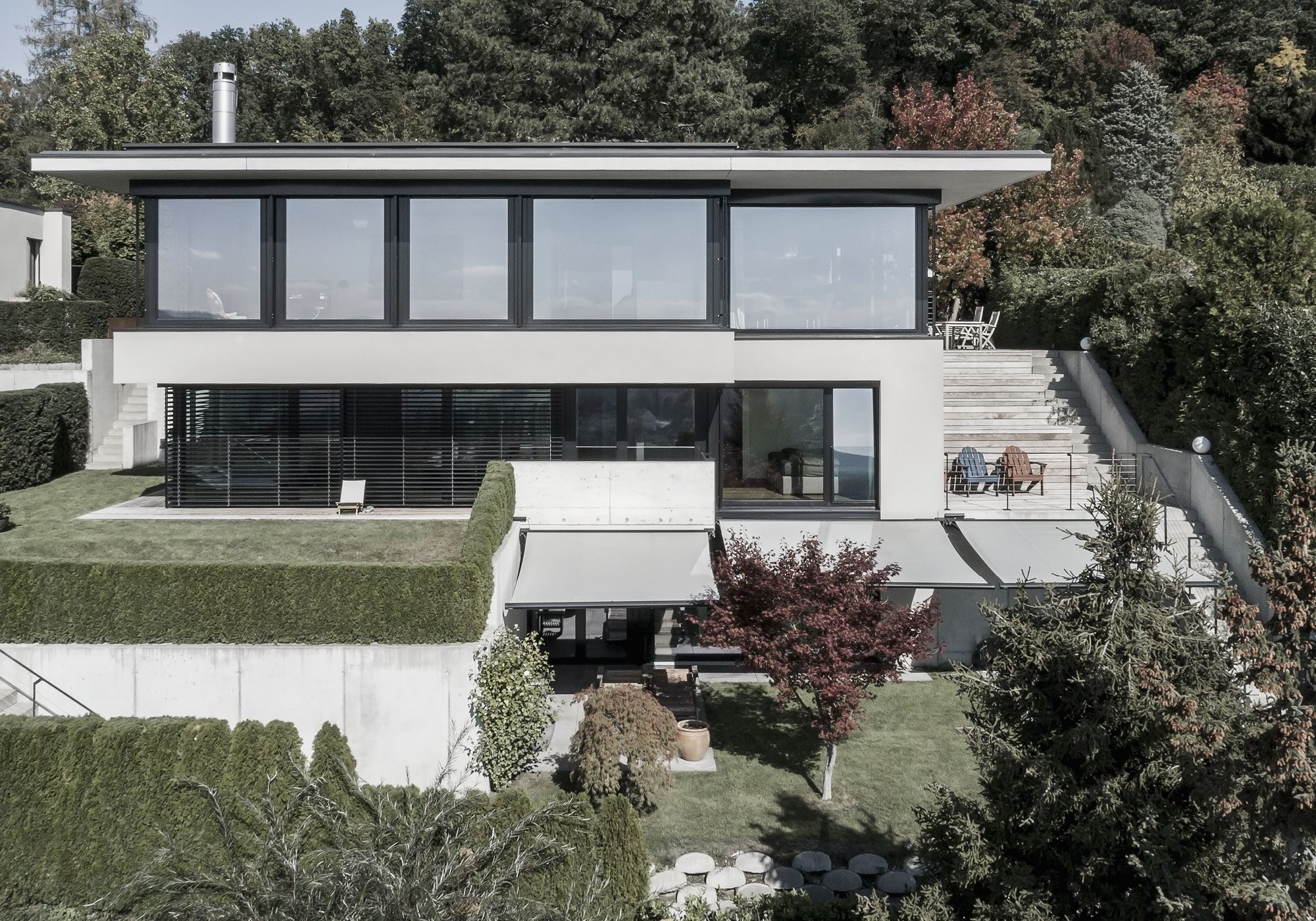 Hillside facade with ribbon windows and awnings – Single-family house in Uitikon