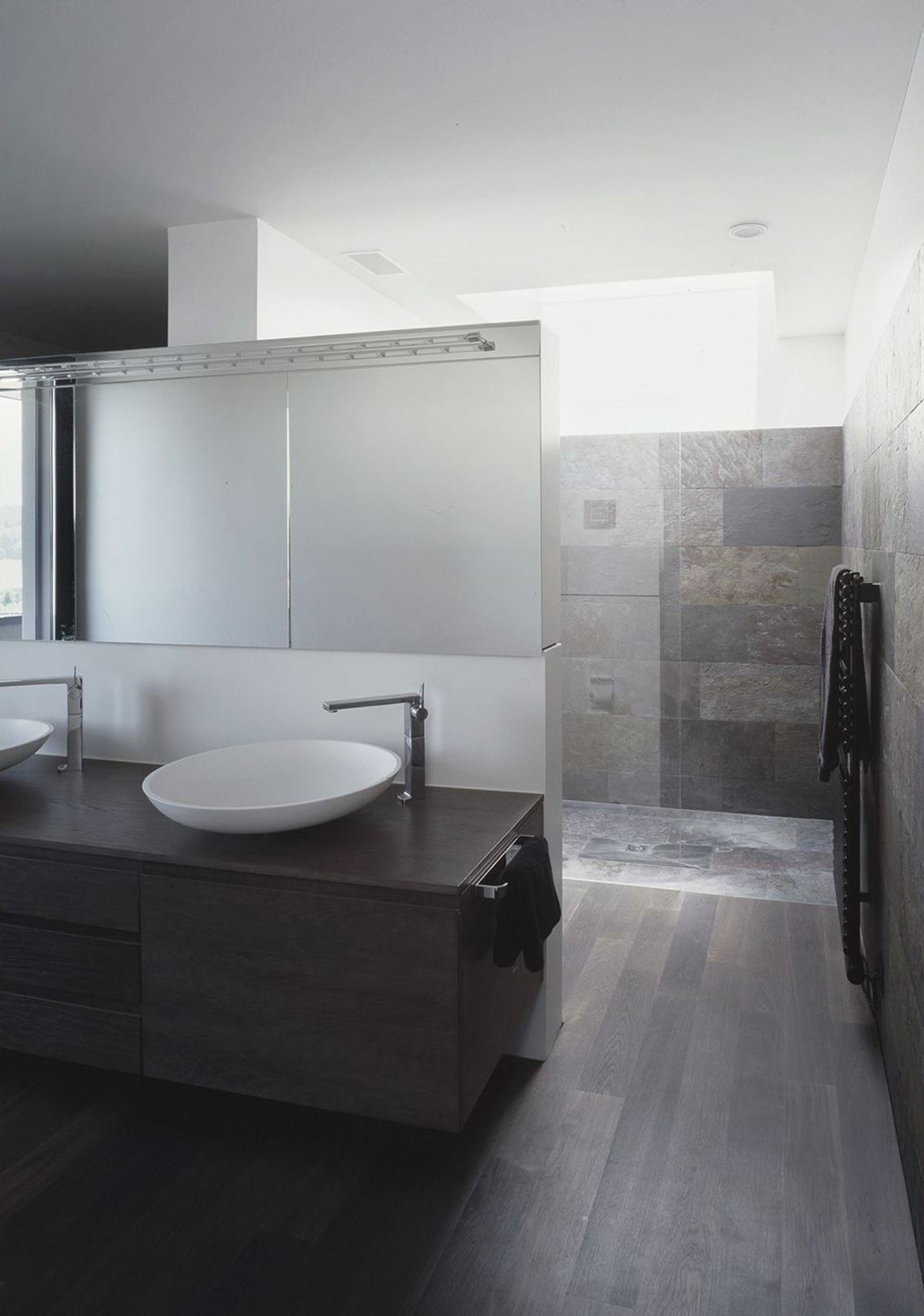 Vanity with countertop basin in front of a mirror – Single-family house in Bonstetten