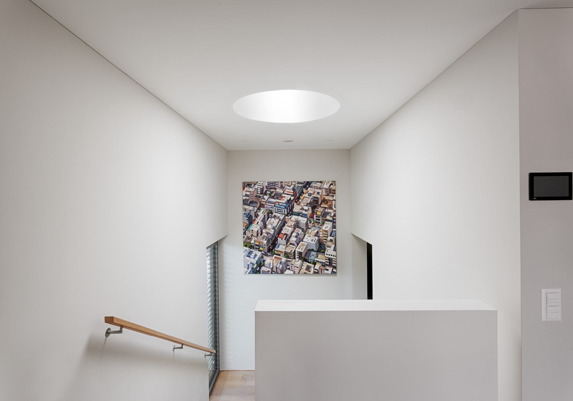 Stair landing with skylight and aerial photograph – Single-family house in Zürich