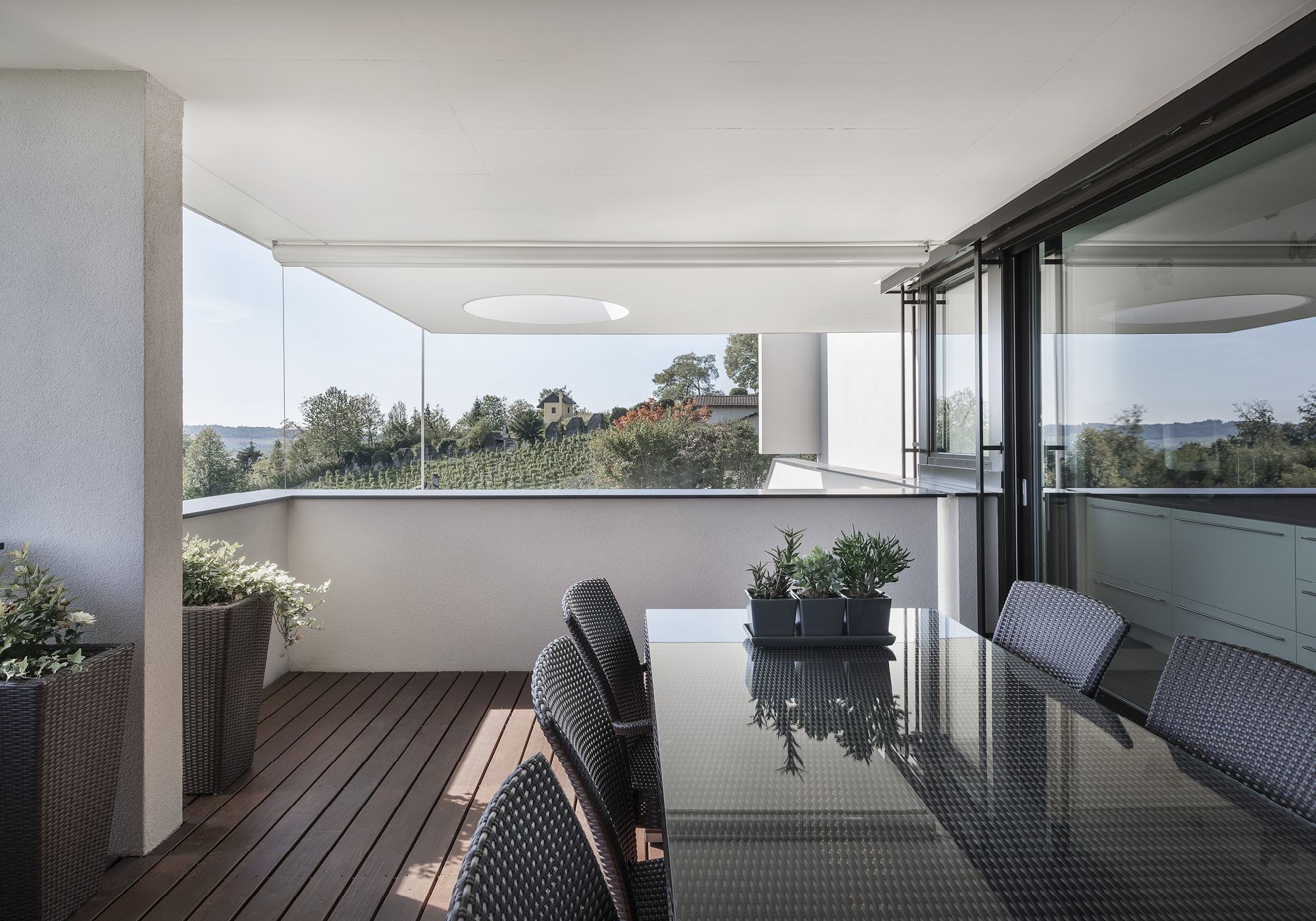Covered seating area with glass table and view – Single-family house in Uitikon