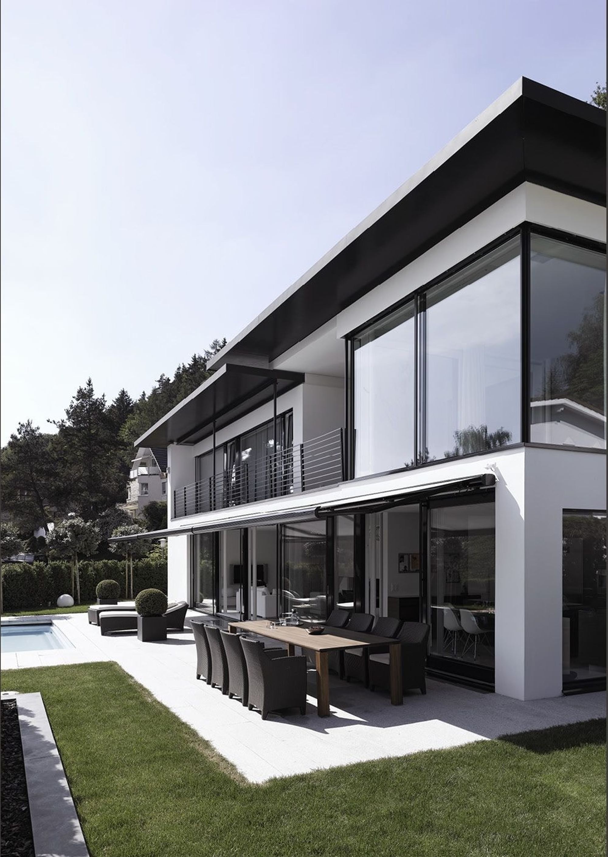 Facade with glass fronts and outdoor dining table – Single-family house in Geroldswil