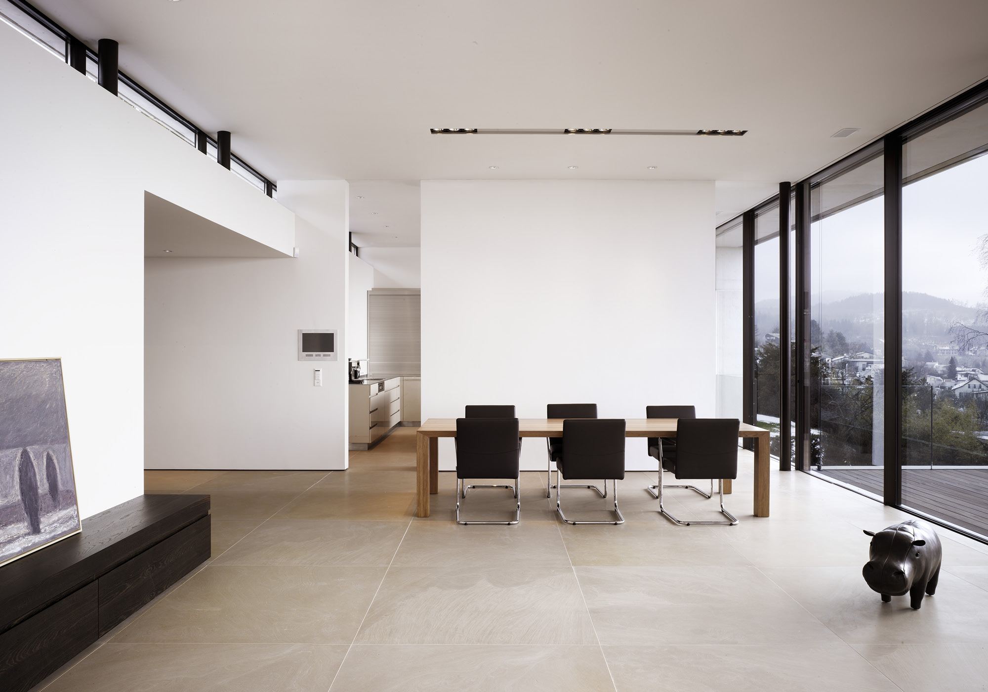 Dining area with black chairs by the glass front – Single-family house in Uitikon