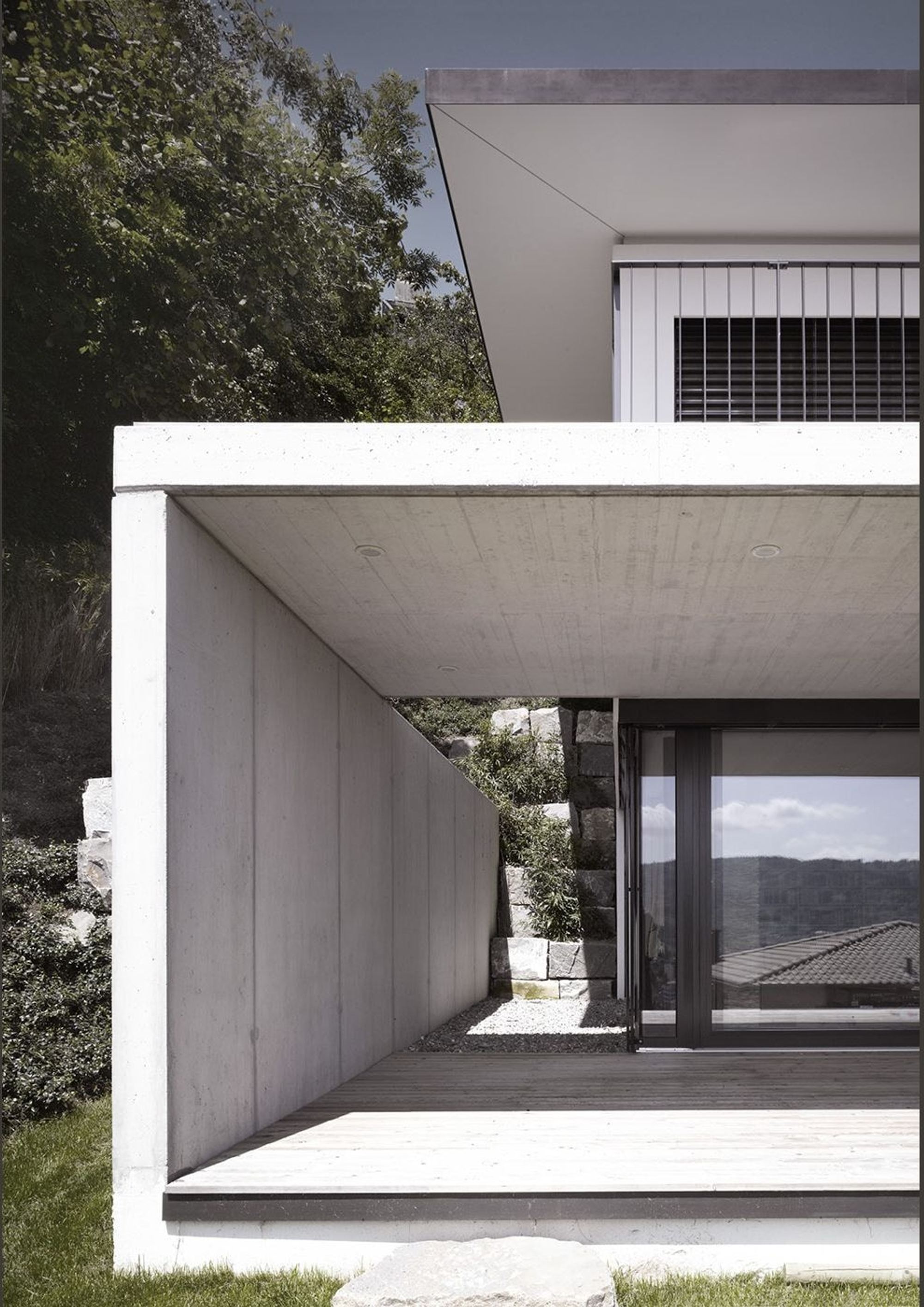 Covered outdoor space with exposed concrete wall – Single-family house in Wettingen