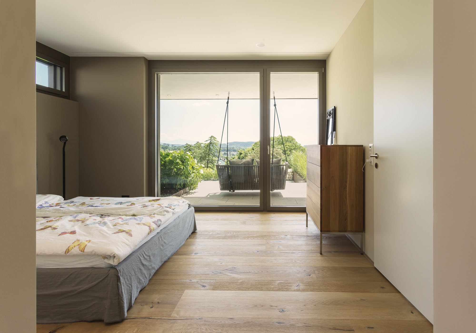 Bedroom with French window and green view – Single-family house in Uitikon