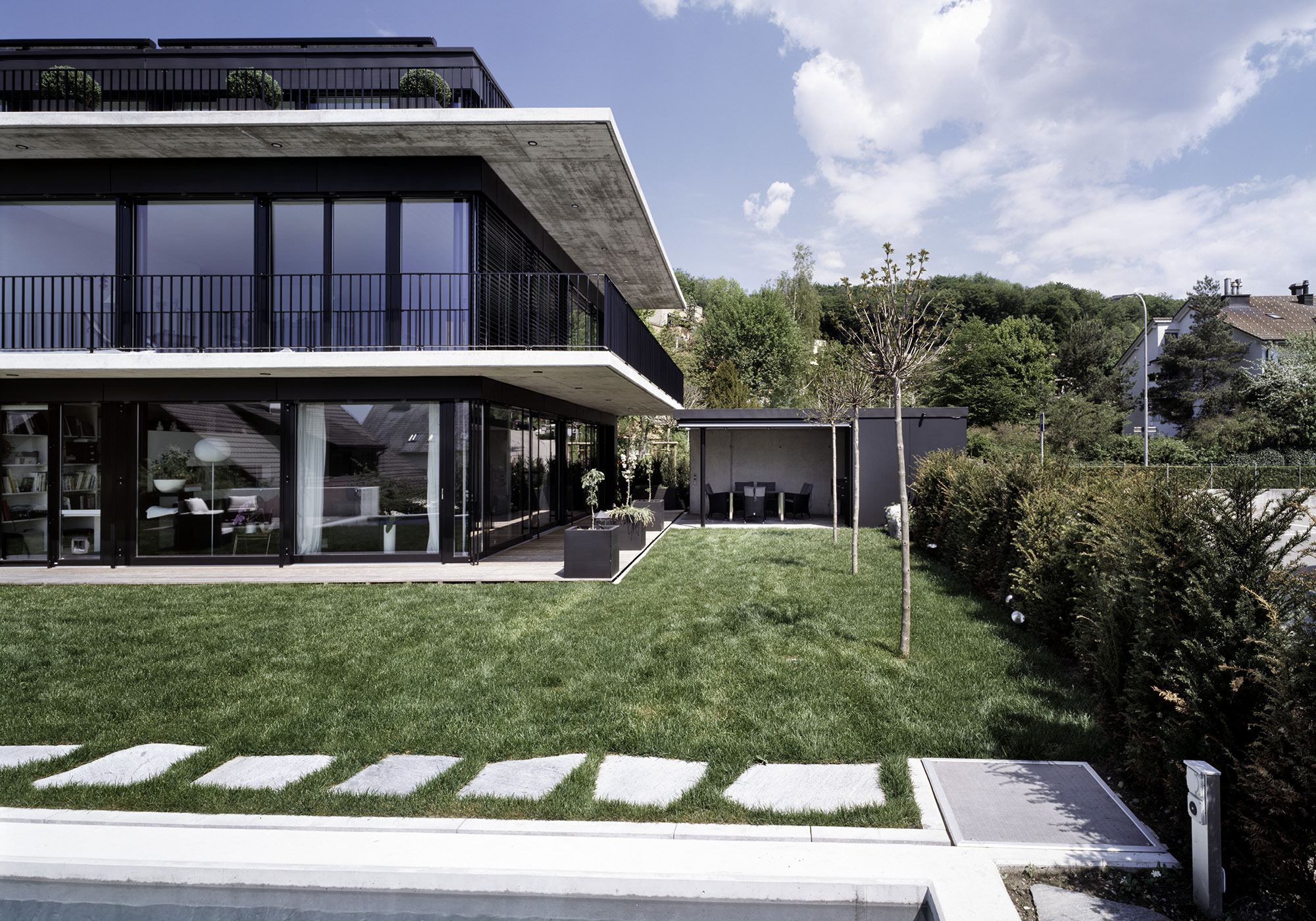 Garden with stepping stones and cantilevered balconies – Apartment building in Uitikon