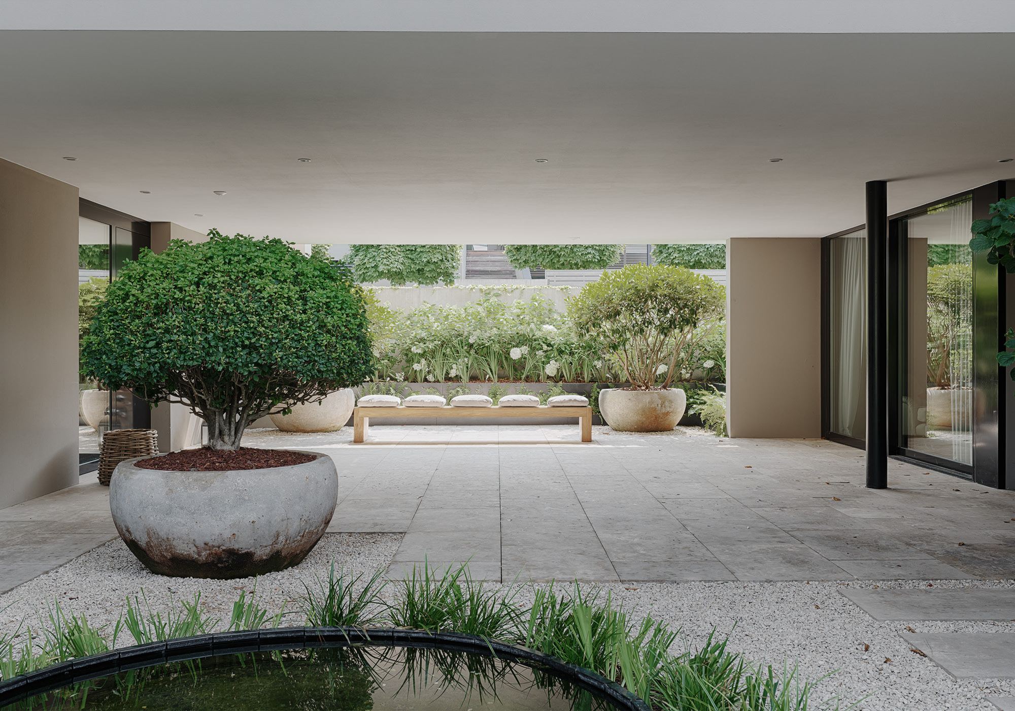 Covered courtyard with planters and round basin – Single-family house in Schindellegi