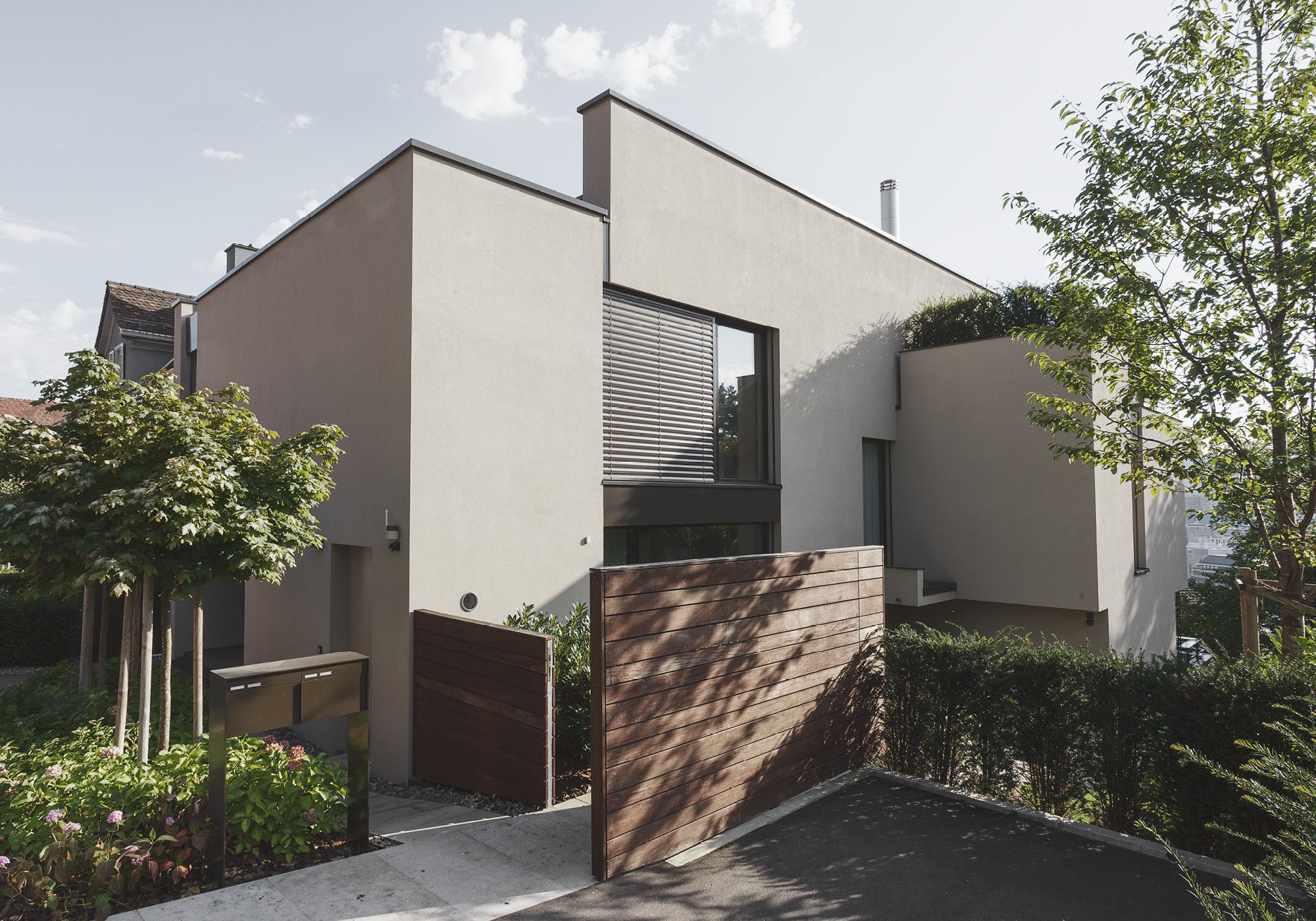 Entrance side with timber gate and front garden – Single-family house in Zürich
