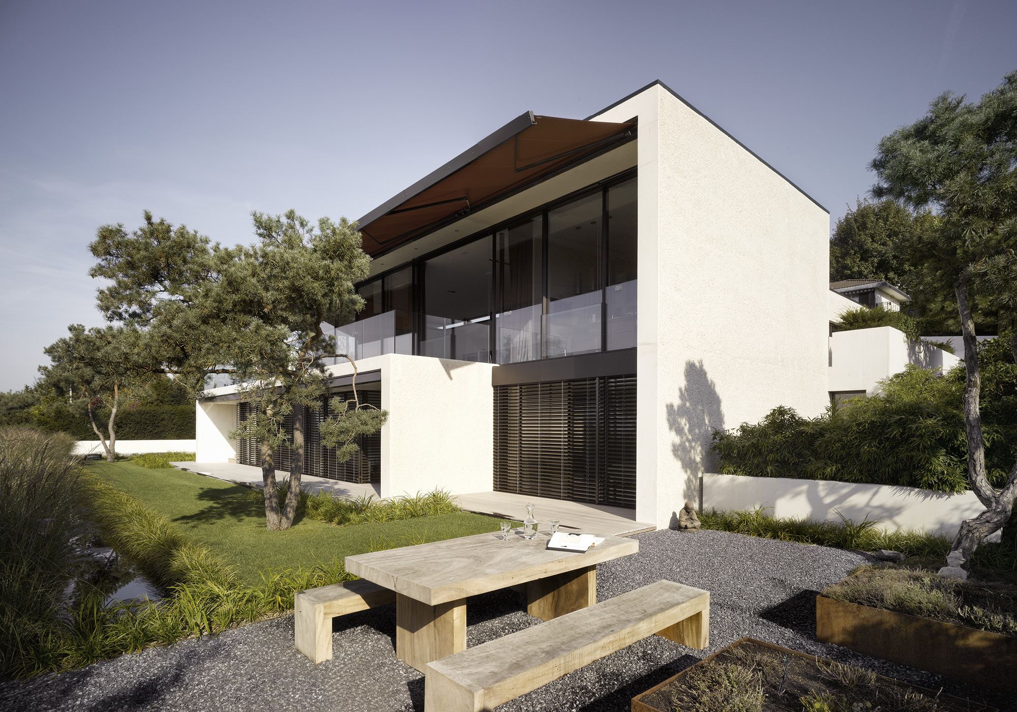 Garden side with timber bench and pines – Single-family house in Uitikon