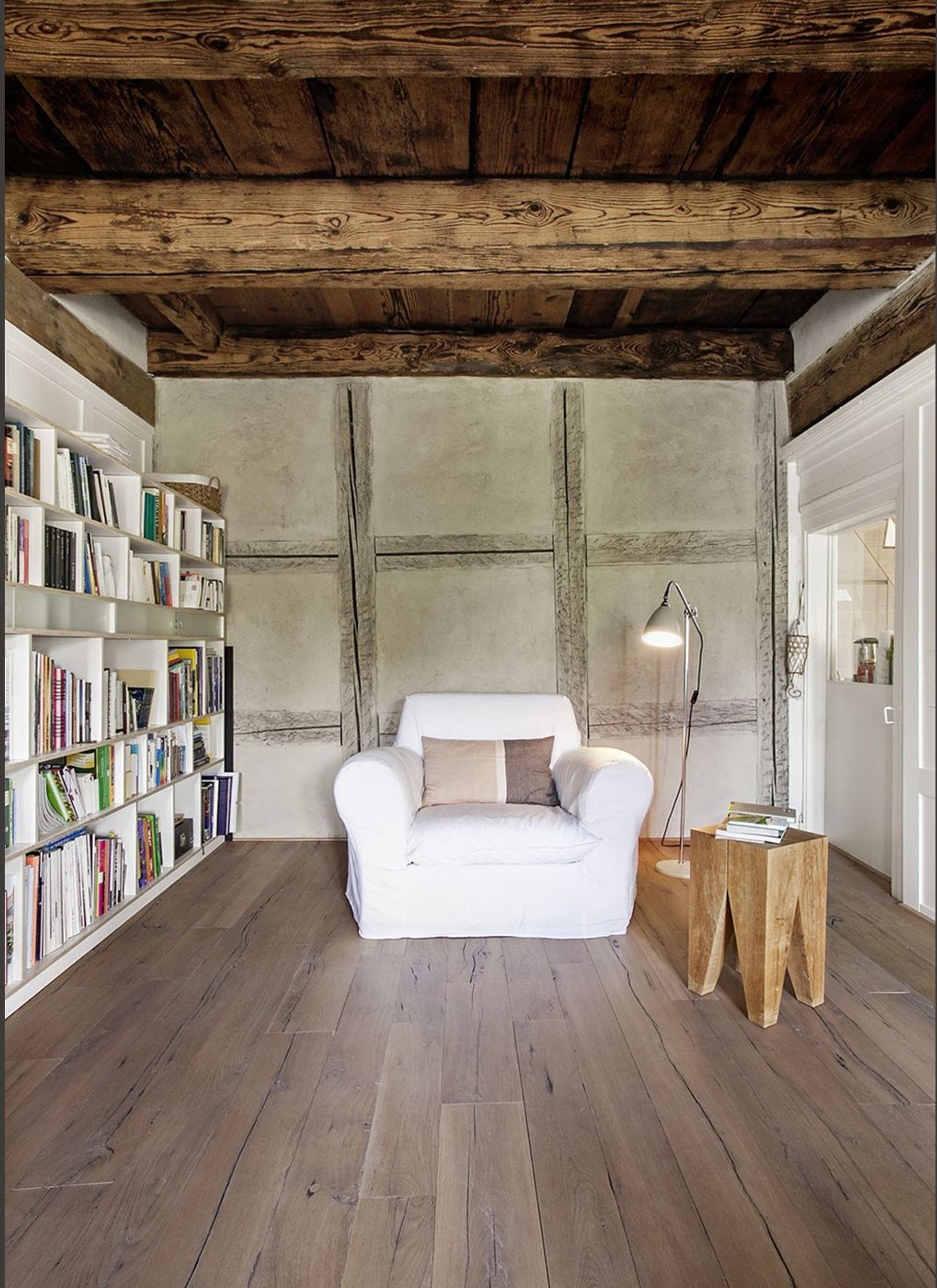 Reading corner with armchair, bookshelves and half-timbered wall – Historic conversion in Uerikon