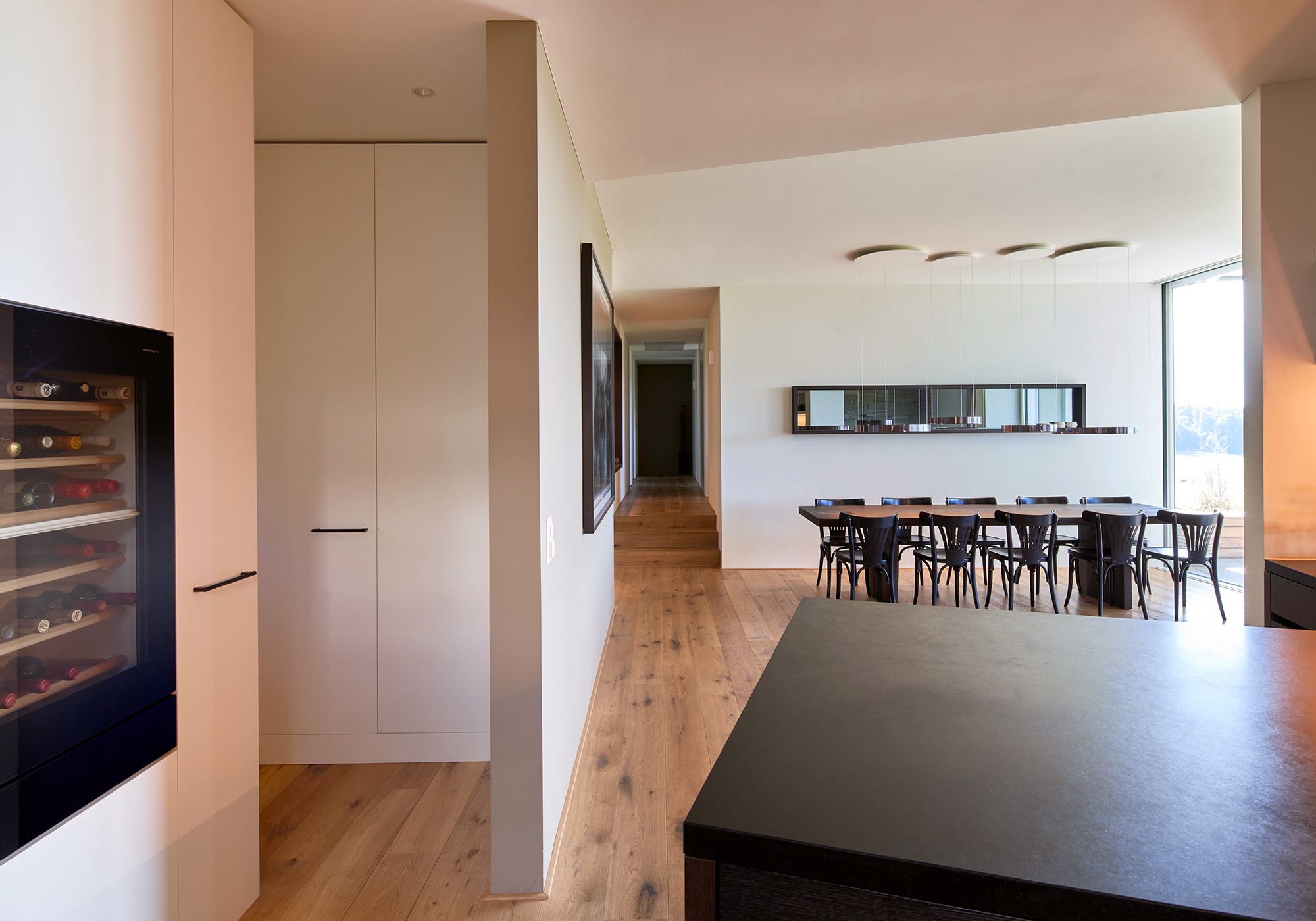 Kitchen with wine fridge and view to the dining table – Interiors and landscape, Lufingen