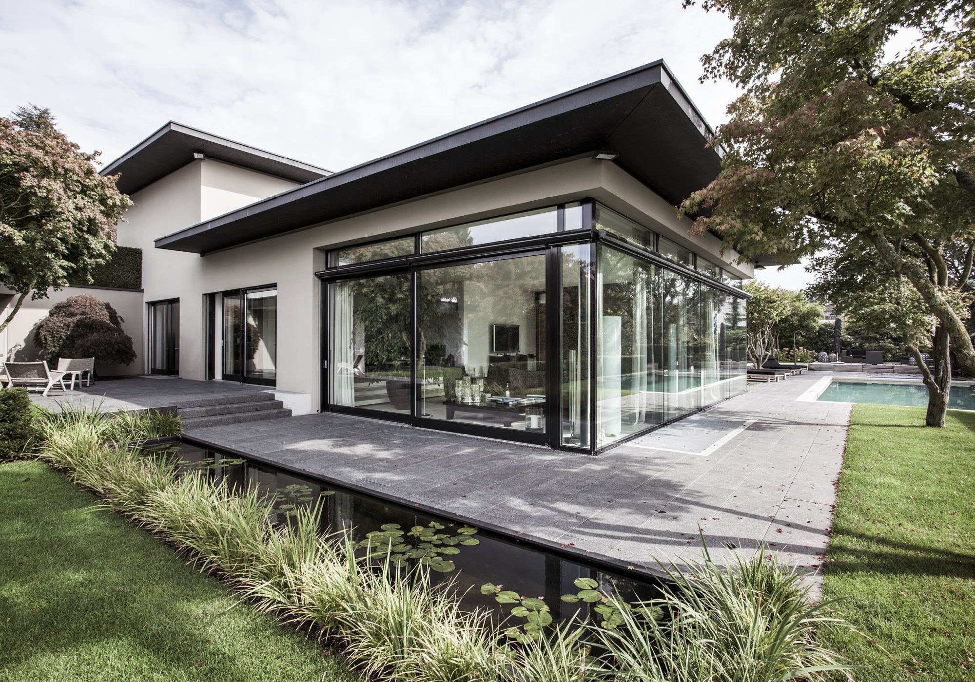 Glass pavilion with wide roof and water basin – Single-family house in Uitikon