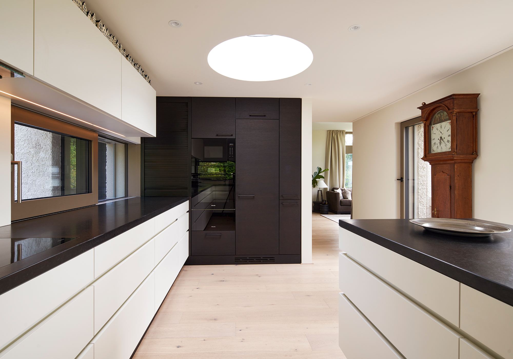 Kitchen with dark worktop and grandfather clock – Interiors and landscape, Wettswil