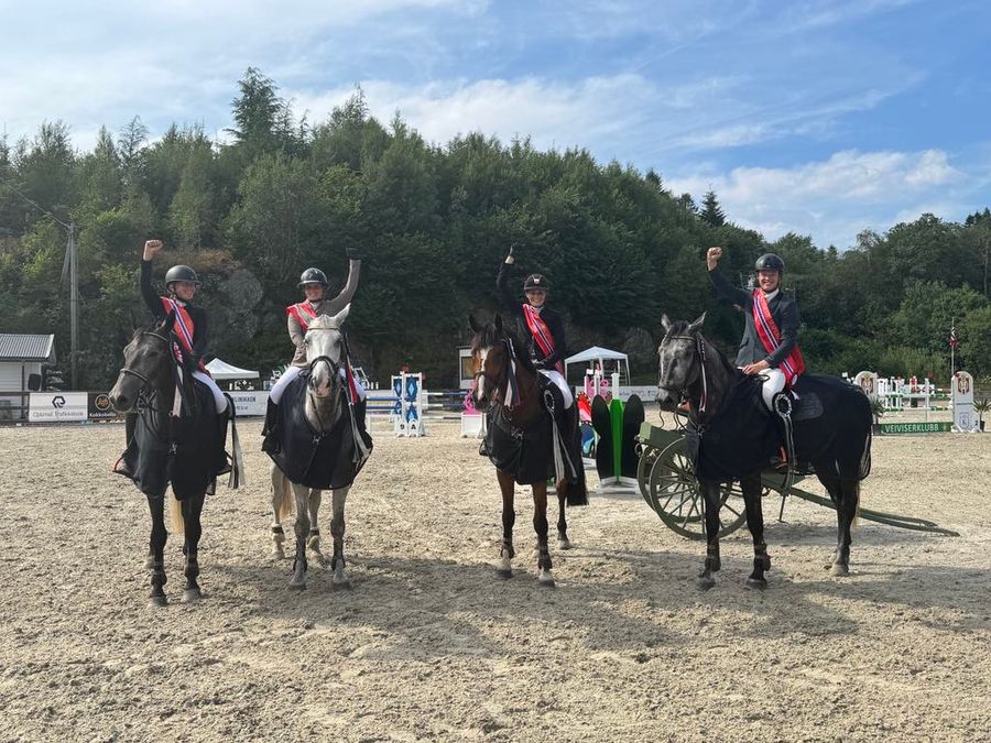 De fire lagrytterne fra Tønsberg og Omegn Rideklubb  løfter hendene i glede over seier i 2. divisjon. (Foto: Elin Seim)