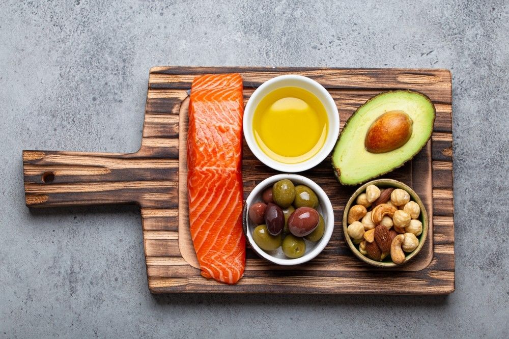 Omega-3 šaltiniai: lašiša, alyvuogių aliejus, alyvuogės, avokadas ir riešutai