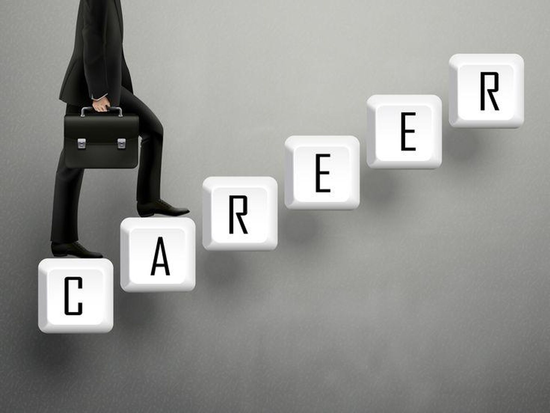 A person in a suit climbs steps made of keyboard keys spelling "CAREER."