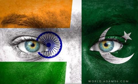 Two faces, one painted with the Indian flag and the other with the Pakistani flag, each with a prominent eye.