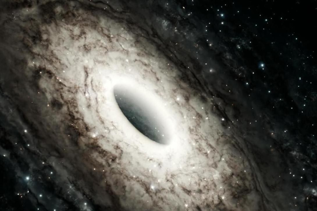 A brightly glowing black hole surrounded by a swirling accretion disk in a starry galaxy.